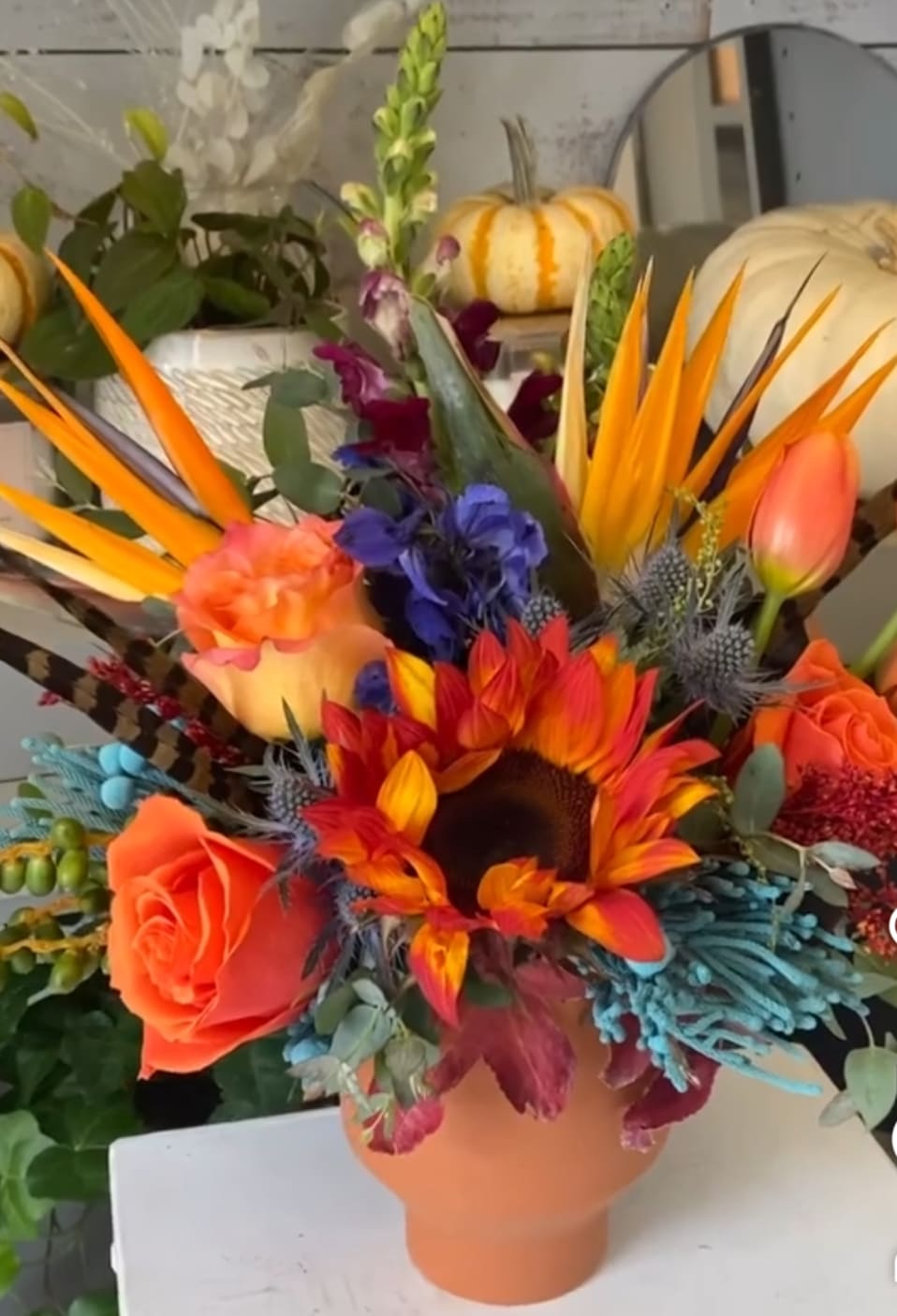 Tropical Sunflower &amp; Bird of Paradise Arrangement – Same Day Delivery San Antonio - Unique tropical flower arrangement in San Antonio by Snyder Flowers featuring fresh sunflowers, bird of paradise, orange roses, tulips, thistle, seasonal greenery and textured foliage designed in a modern ceramic vase perfect for Mother’s Day, birthdays, congratulations and bold floral gifts with same day flower delivery in San Antonio, premium quality fresh flowers and affordable prices for a vibrant and artistic floral design