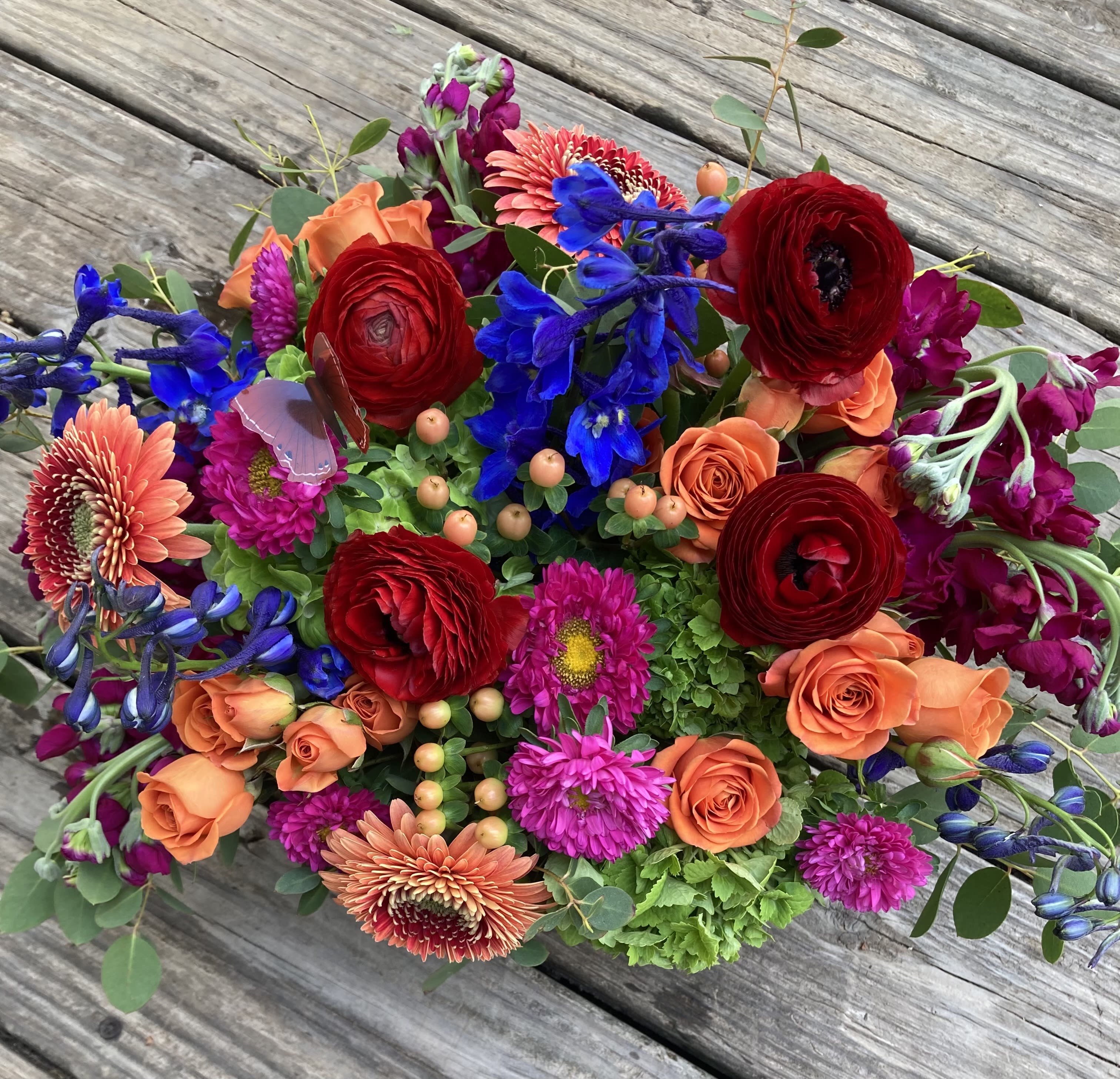 Colorful mixed bouquet with red, orange, blue, and pink flowers