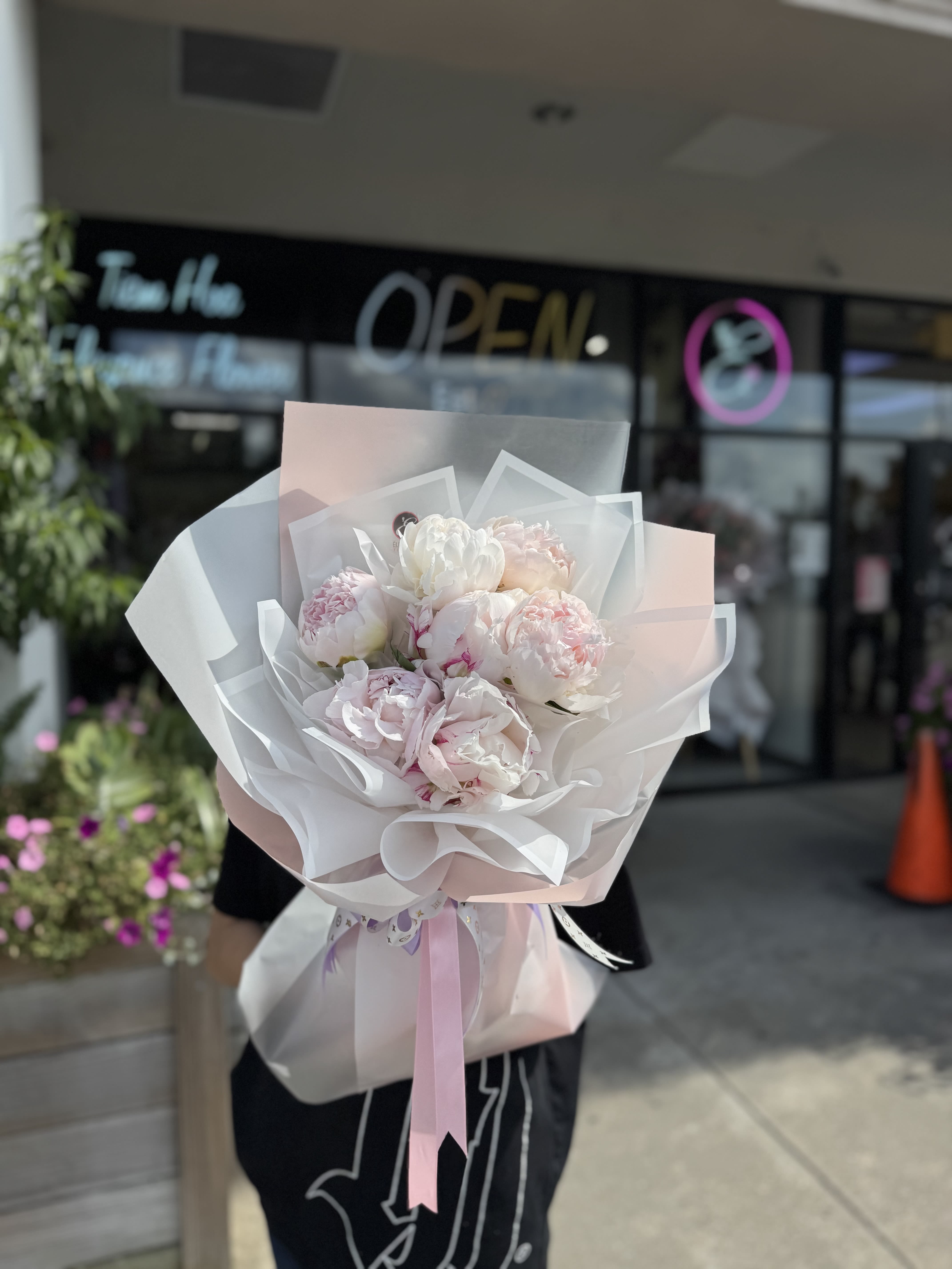 Pink and white peony bouquet wrapped in translucent paper