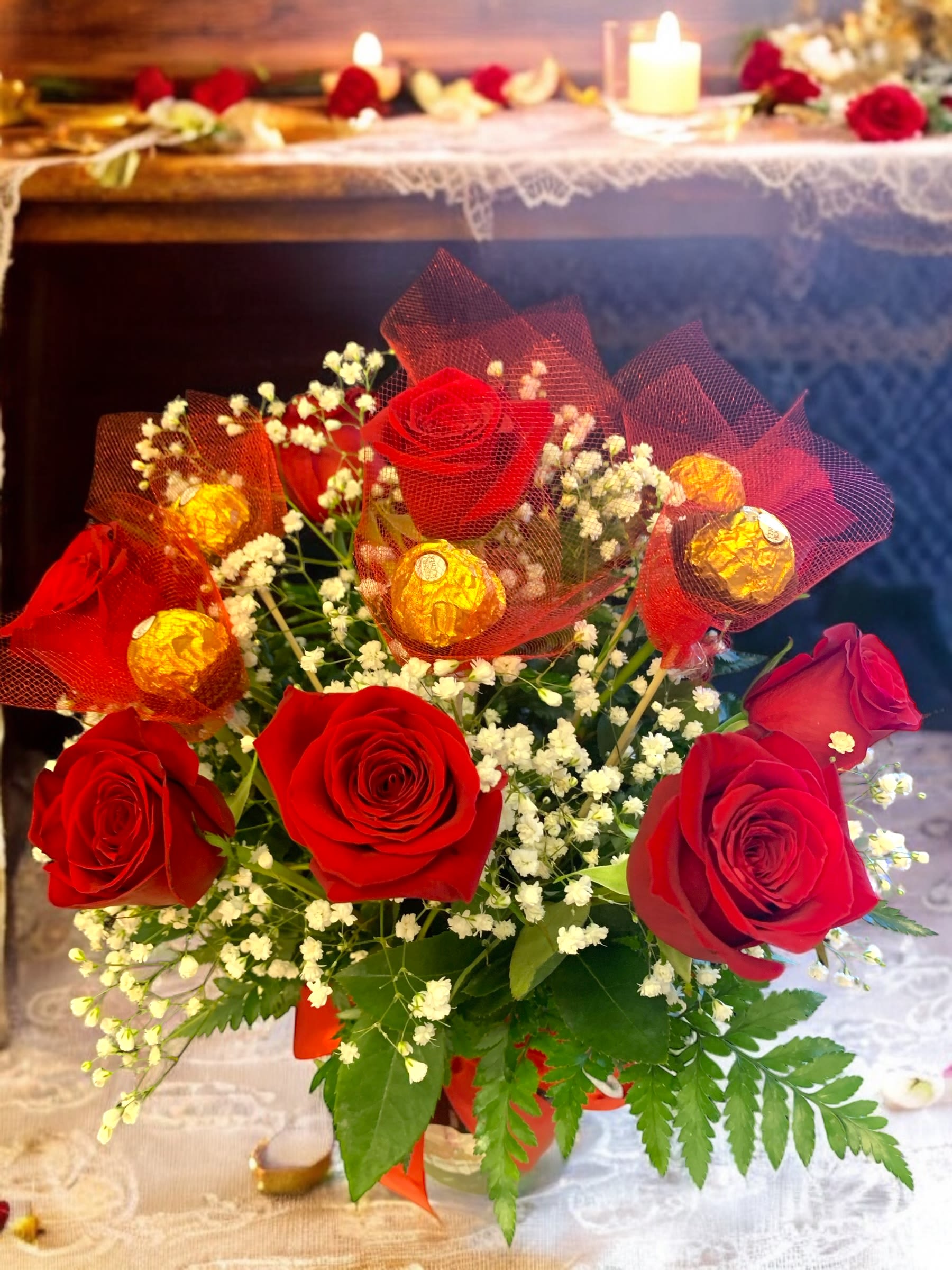 Red roses with baby’s breath and wrapped chocolates in a bouquet