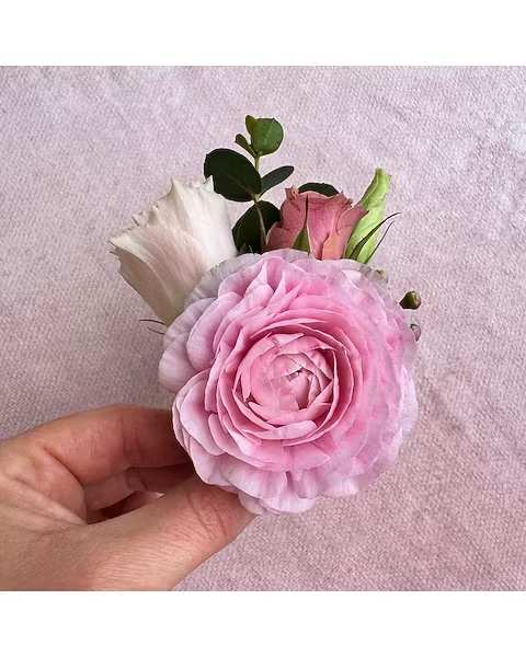 Pink Boutonniere - All of our boutonnieres include multiple blooms with touches of greenery. Each boutonniere is wrapped in a thin tie of silk ribbon and two boutonniere pins are included.
