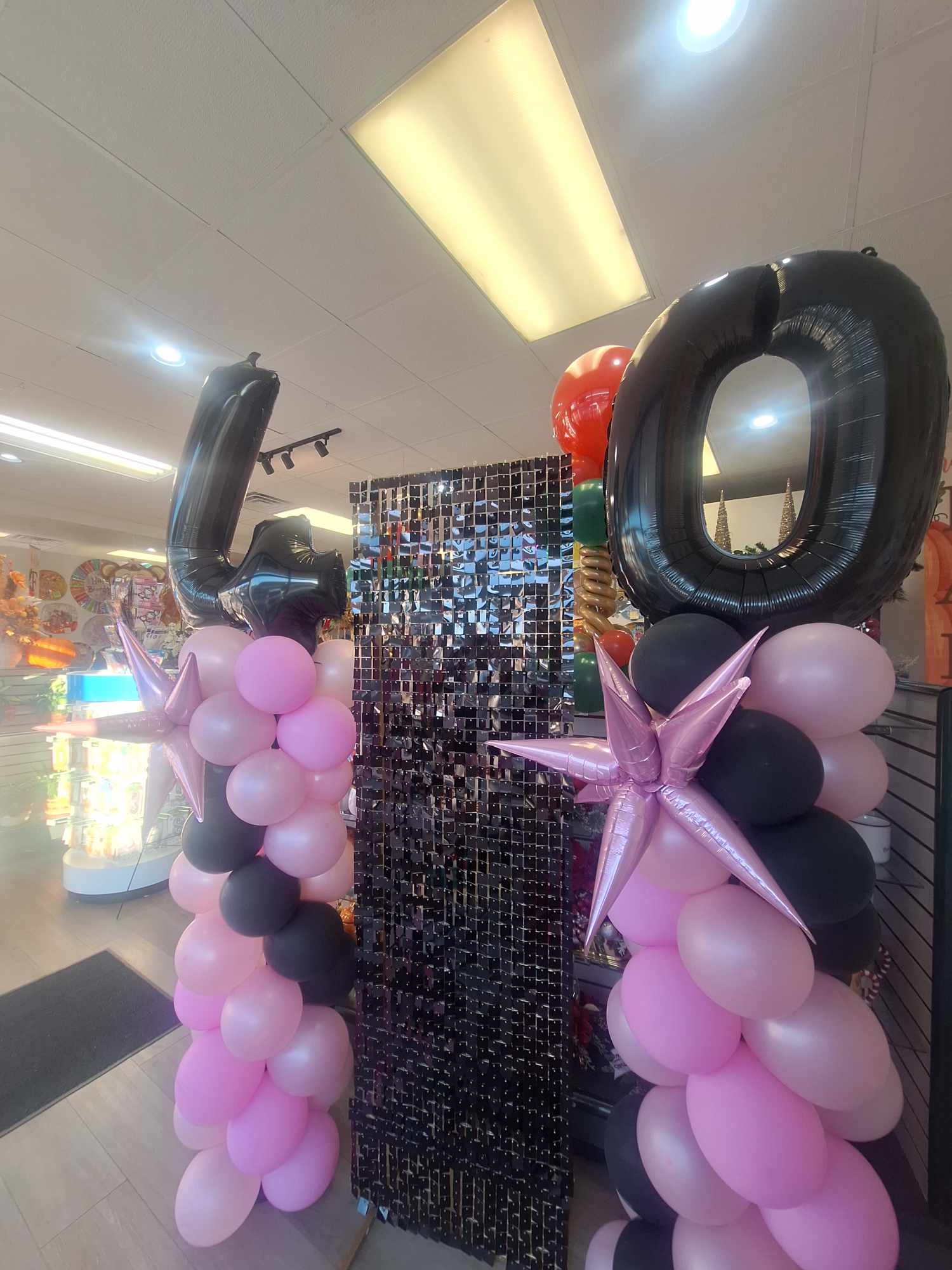 Balloon display with large black 40 numerals and pink, black, and lavender balloons