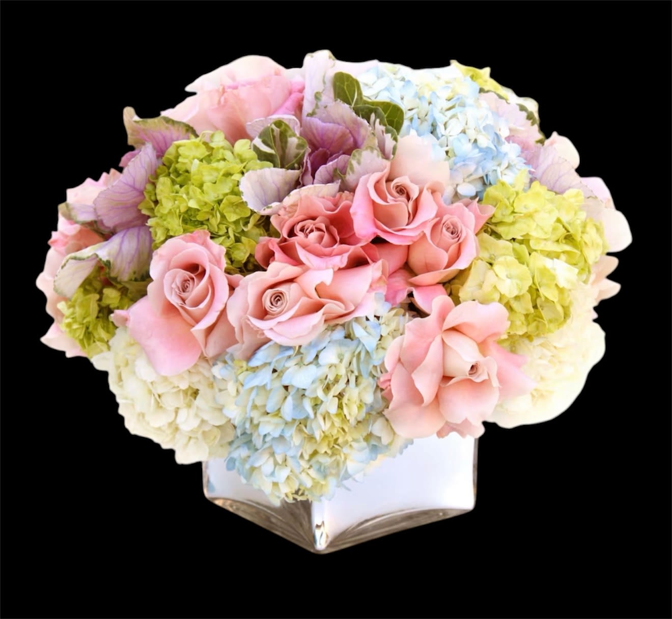 Pink roses and pastel hydrangeas arranged in a white vase