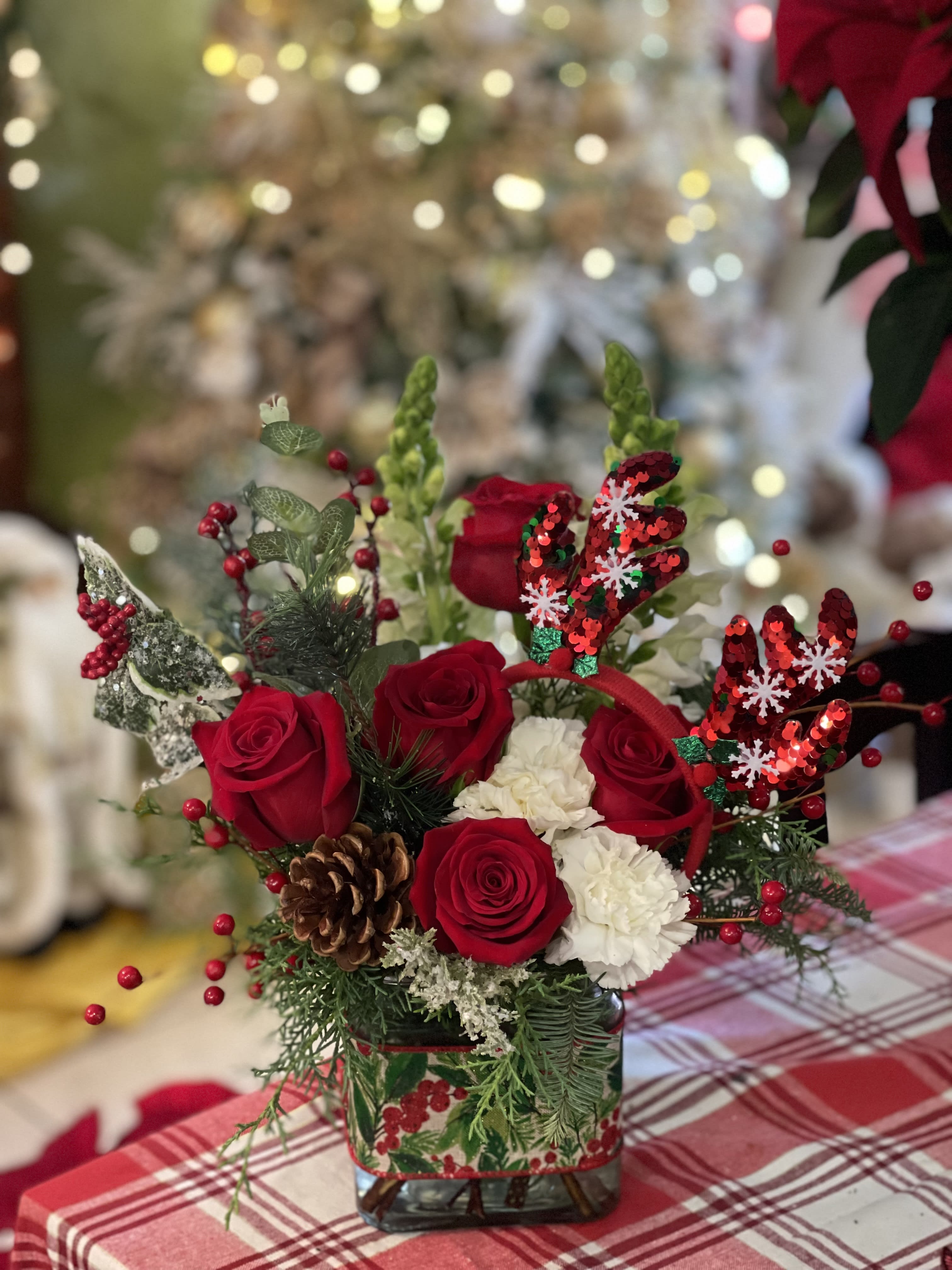 Rudolph The red nosed reindeer  - designed in a glass cube with fresh winter greens lush red roses and a Glistening set of Reindeer antlers is included with each bouquet 