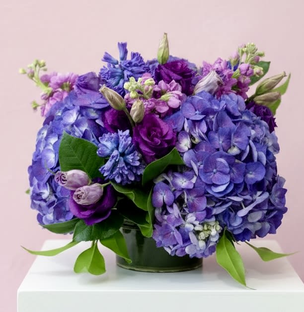 Purple and blue hydrangea bouquet in a glass vase