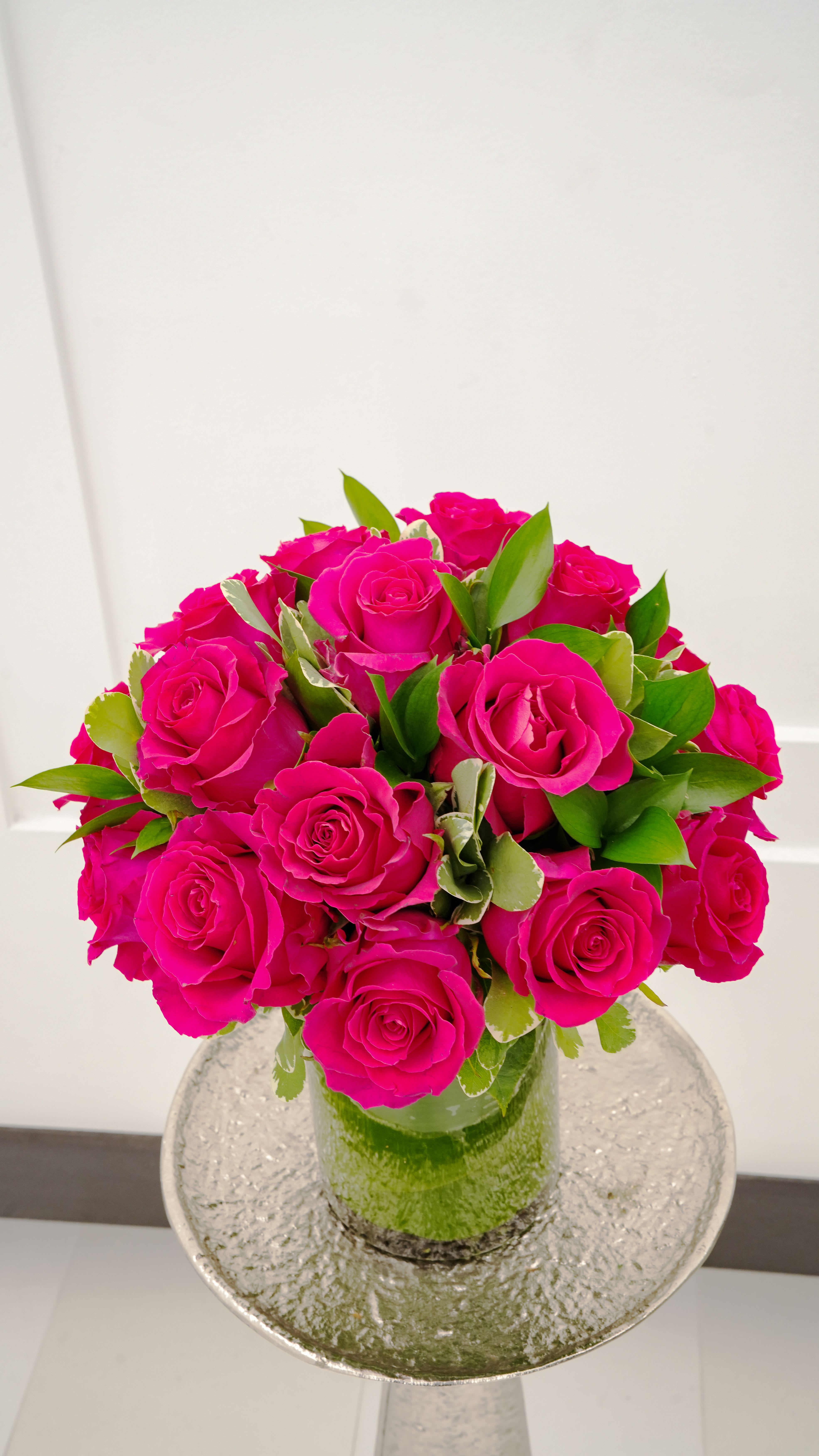 Bouquet of bright pink roses in a clear glass vase