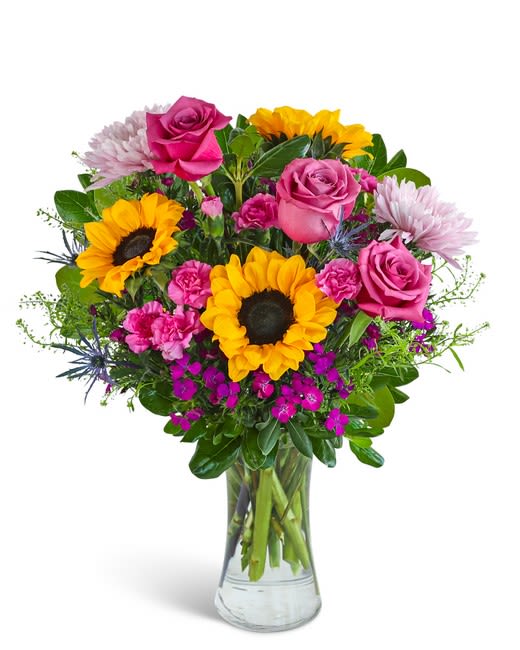 Perfect Blooms - Bright sunflowers and vivid pink roses make a joyful statement in this flower arrangement, perfect as a birthday bouquet, anniversary gift, or a cheerful Mother's Day surprise. The "Perfect Blooms" composition reads like a sunny garden - the large yellow sunflower faces instantly draw the eye while the pink roses send a warm, romantic message, making it equally suited for love and romance or a thoughtful "just because" moment.  This clear glass vase arrangement also includes soft lavender-white chrysanthemums and clustered dianthus for delicate texture and contrast against the bold blooms. The design is full and rounded with layered textures: smooth rose petals, the dramatic sunflower centers, and smaller clustered accents that add depth and movement. Colors are bright pink, sunny yellow, white with green foliage that keeps the palette fresh and versatile.  Send this to make someone feel truly celebrated - whether you're welcoming a new baby, saying thank you, marking Admin Professionals' Week, or simply thinking of someone special. Arrives ready to display in the included clear glass vase; trim stems and refresh water every few days to extend bloom life.