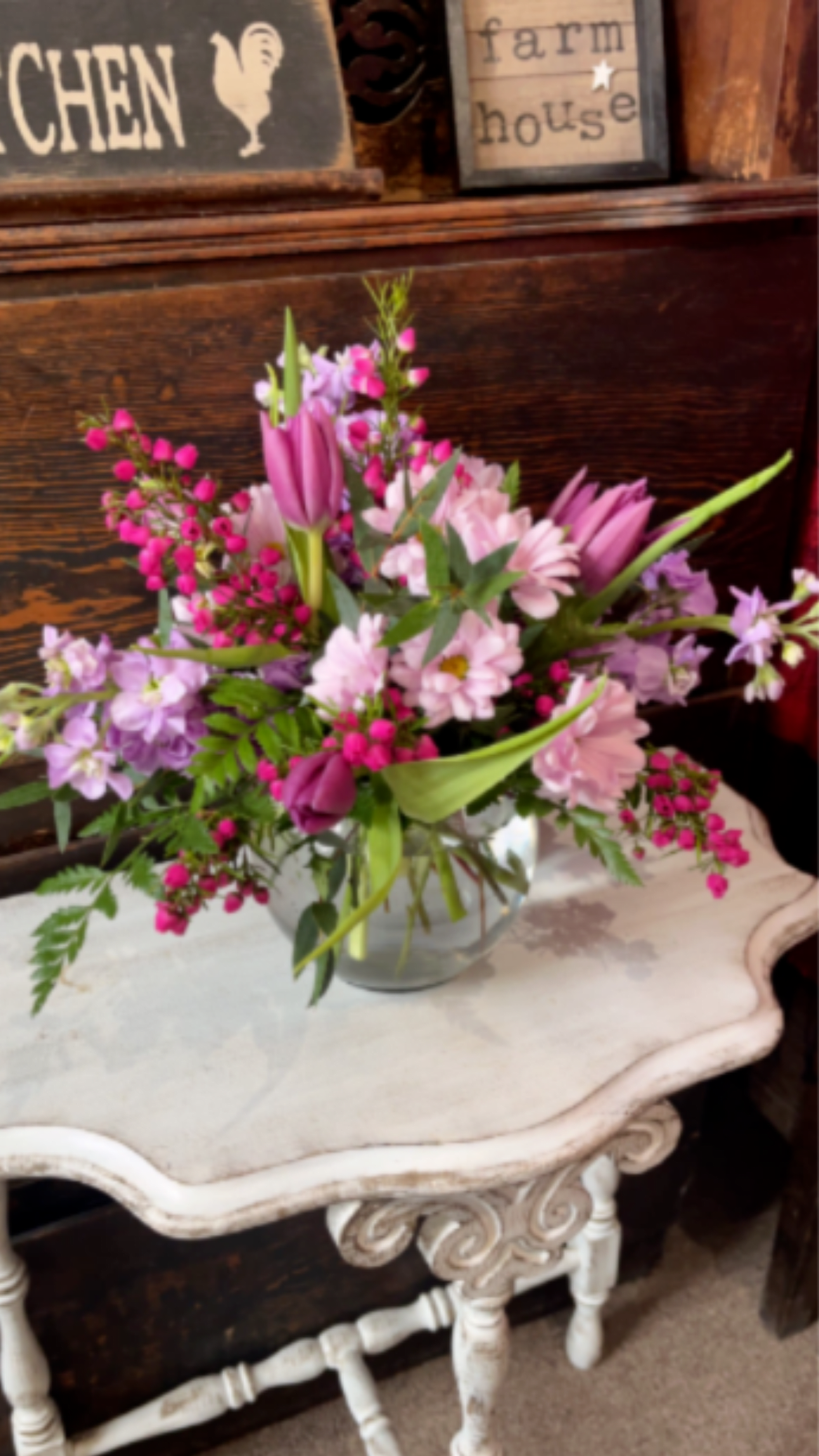 Pink and lavender flowers arranged in a clear glass vase