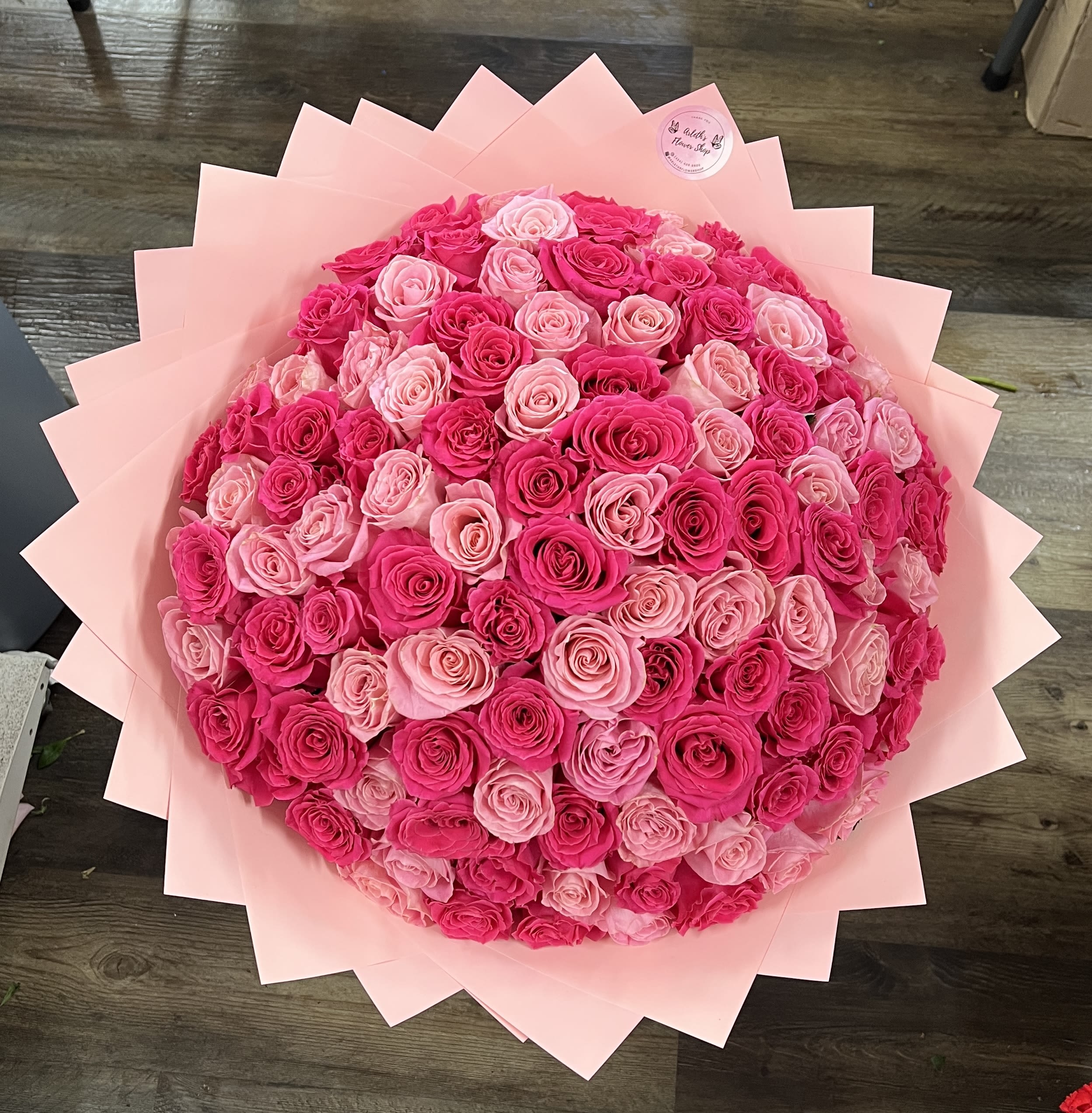 Large bouquet of pink and hot pink roses wrapped in pale pink paper