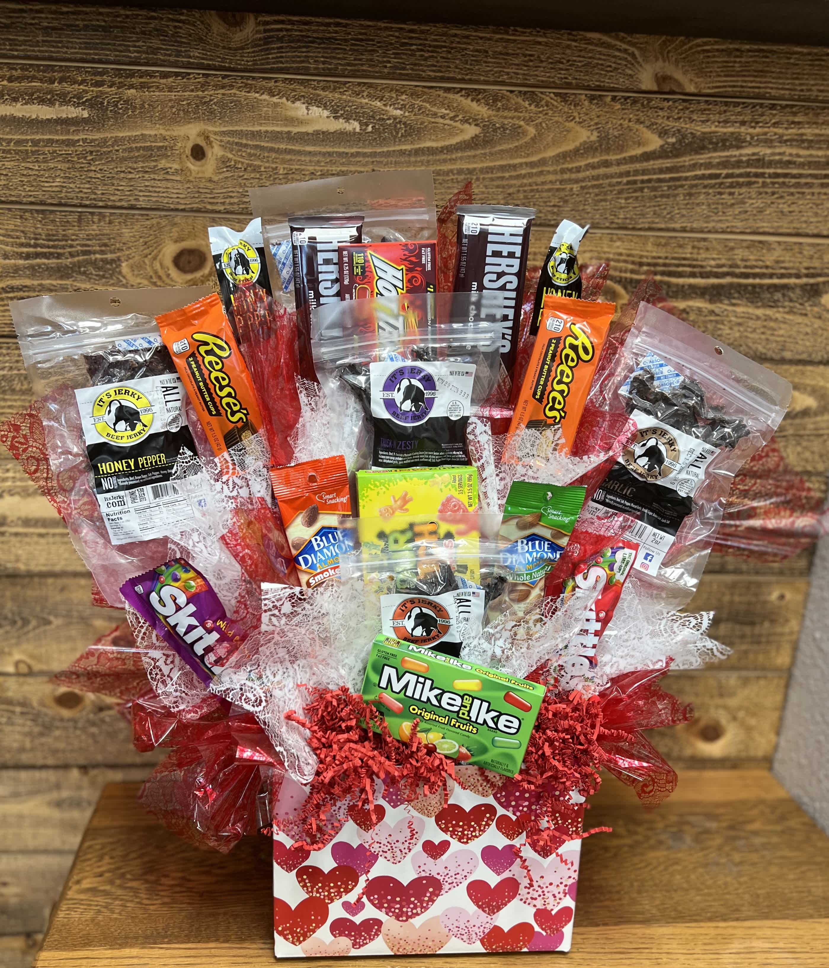 Gift basket of assorted candy and jerky in a heart-patterned box