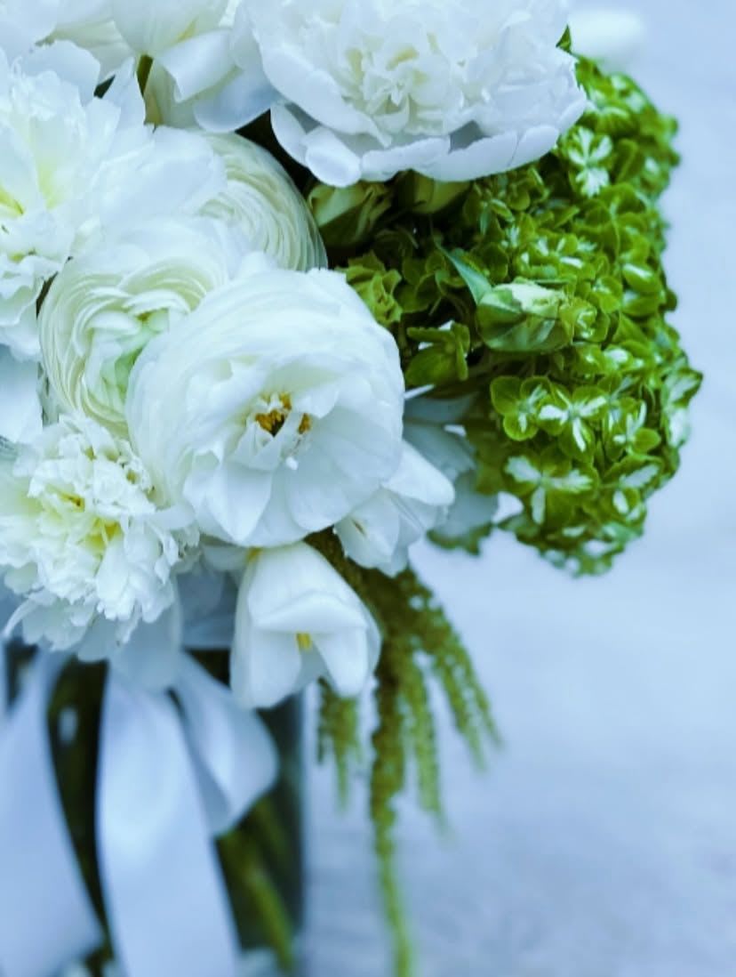 White bouquet with peonies and green hydrangeas tied with a white ribbon