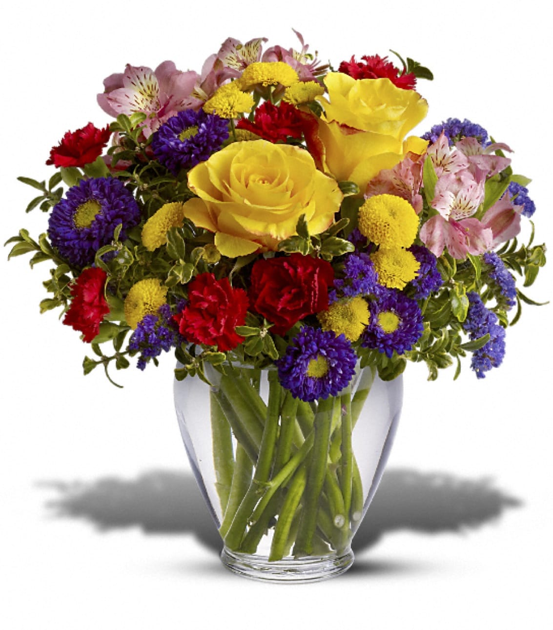 Mixed bouquet of yellow roses, purple daisies, red carnations, and pink alstroemeria in a glass vase