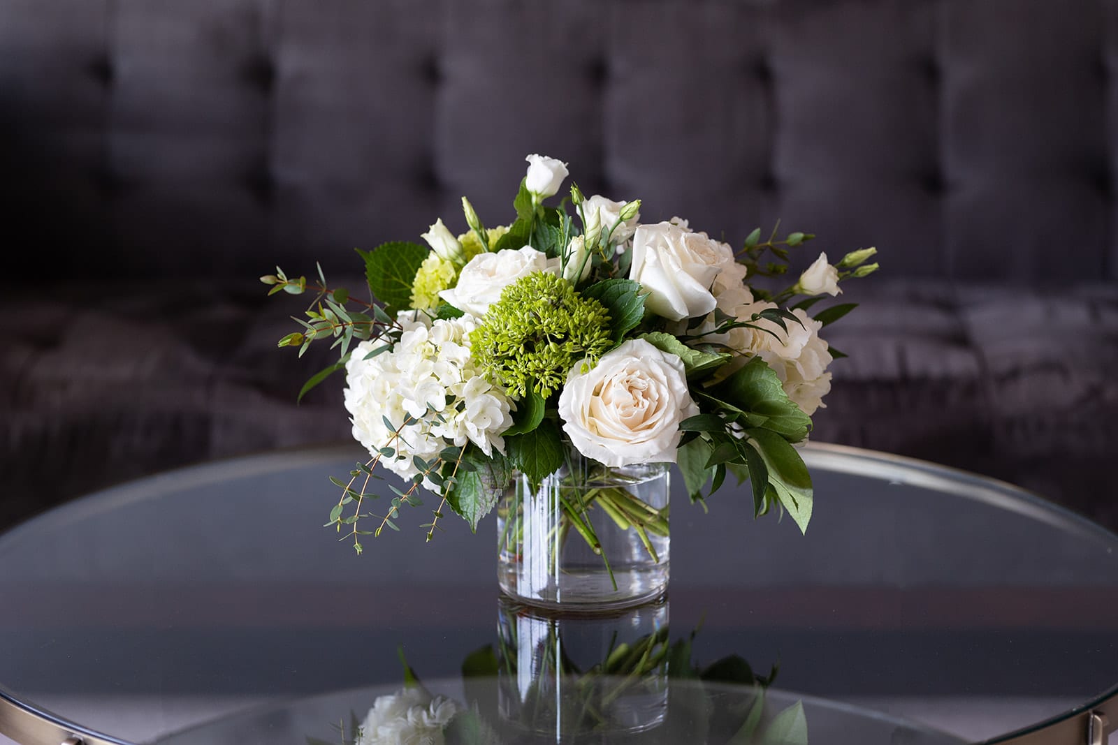 White floral arrangement in a clear glass vase on a table