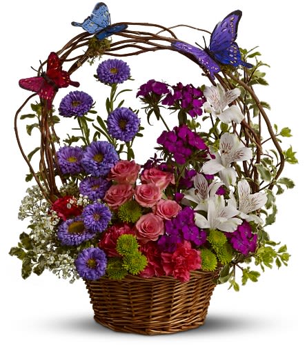 Basket arrangement of purple, pink, white, and red flowers with butterfly picks
