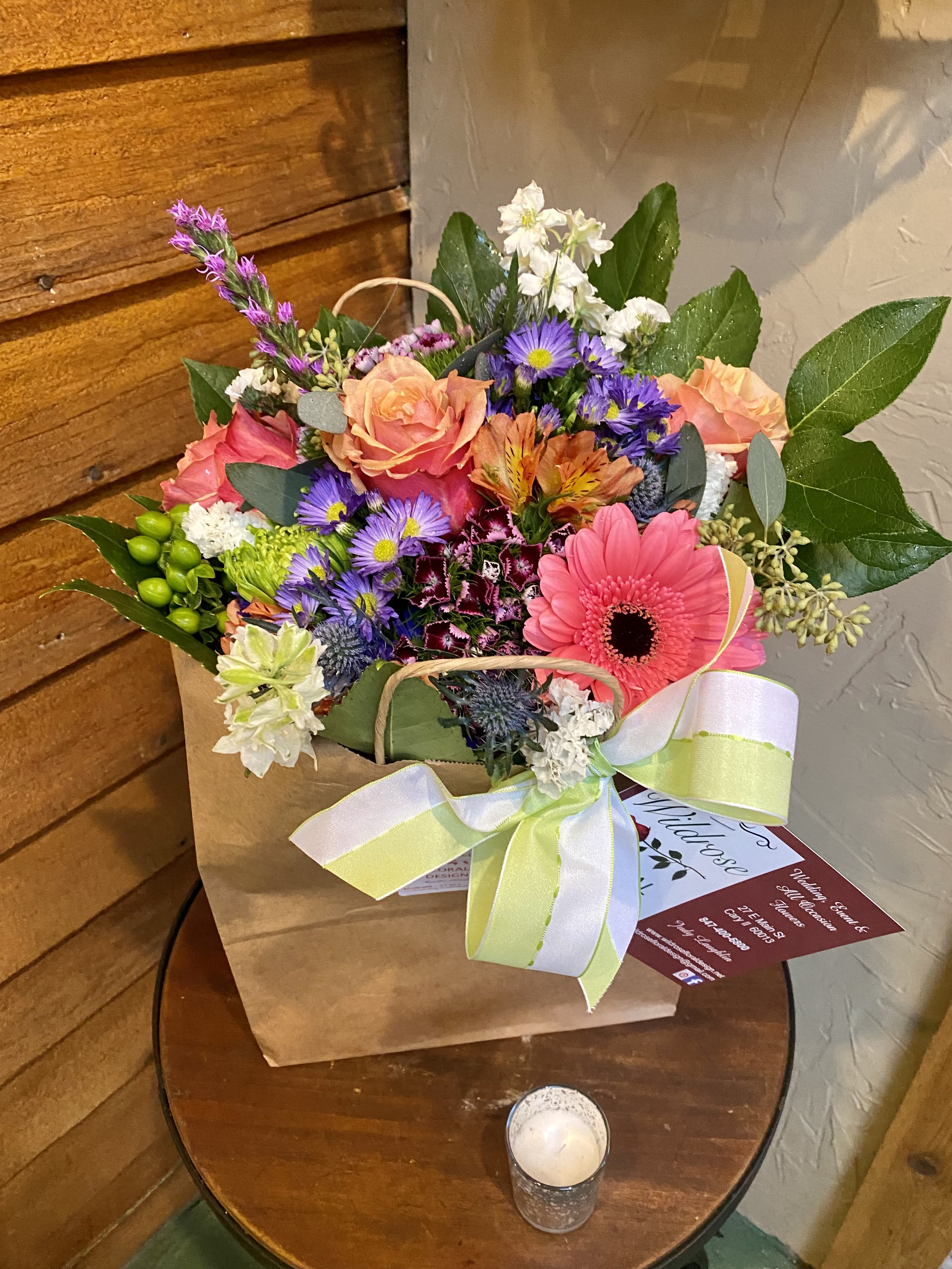 Mixed bouquet in a paper bag with a ribbon bow