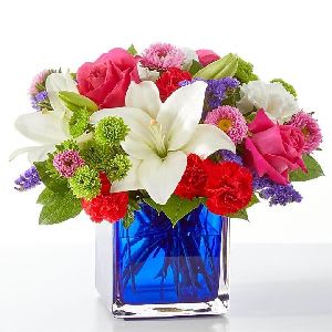 Vibrant &amp; Blue Centerpiece - A lively and colorful arrangement that adds a touch of joy and style to any table.  Each piece is Designer’s Choice, created with fresh seasonal blooms. Flowers and colors may vary based on availability while maintaining the overall style and quality.  Best for: brightening family dinners, elevating baby showers, or enhancing casual celebrations. 