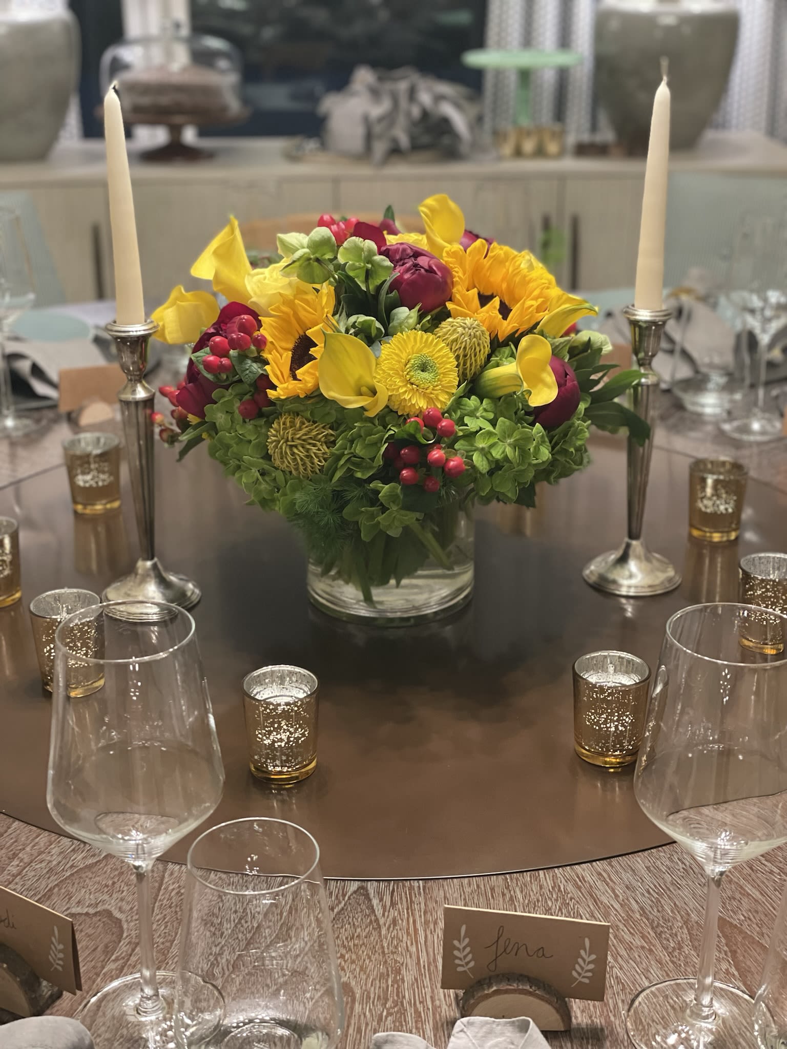 Bright yellow and magenta floral centerpiece in a glass vase on a table