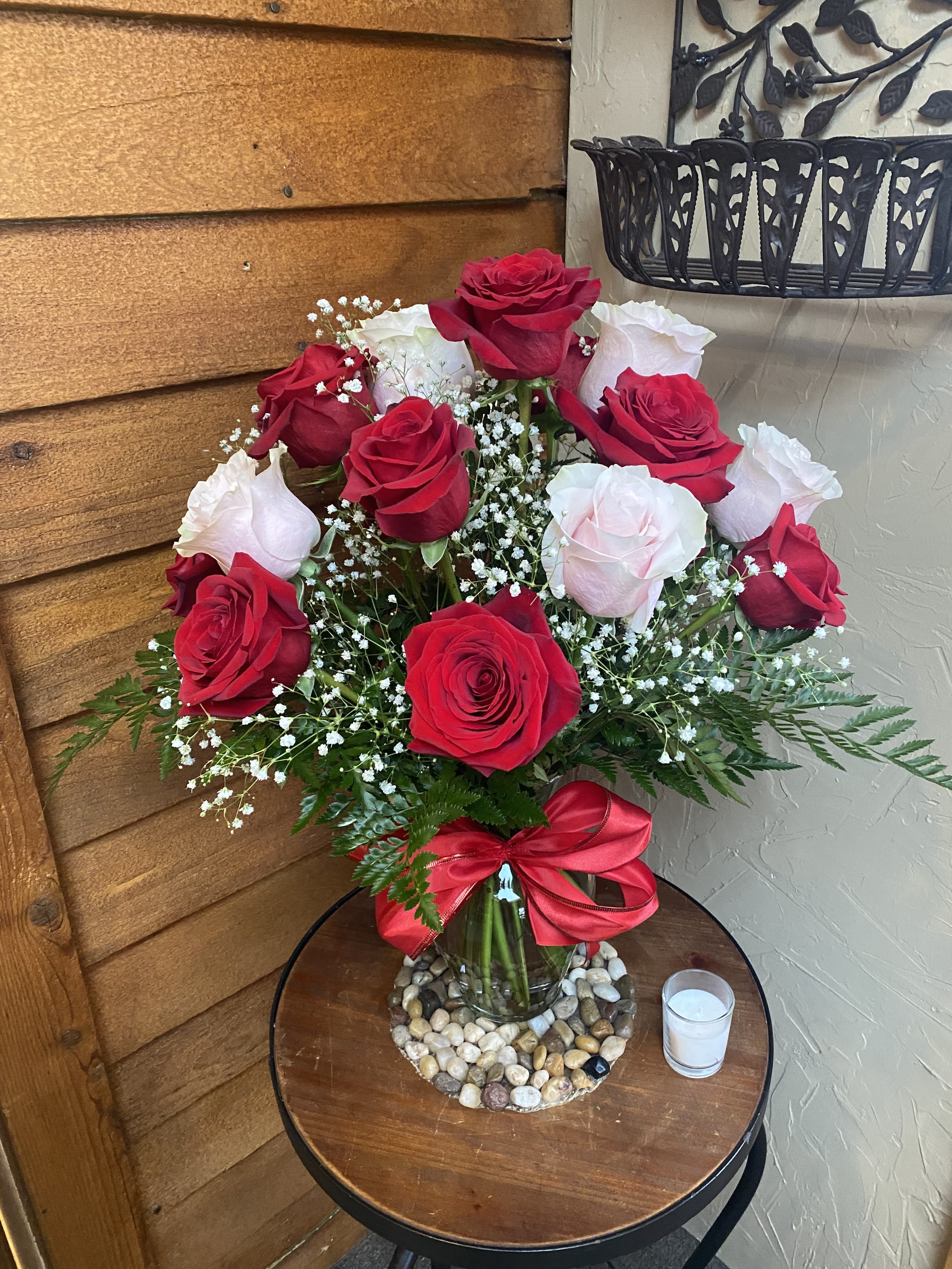 Bouquet of red and white roses in a glass vase with a red ribbon