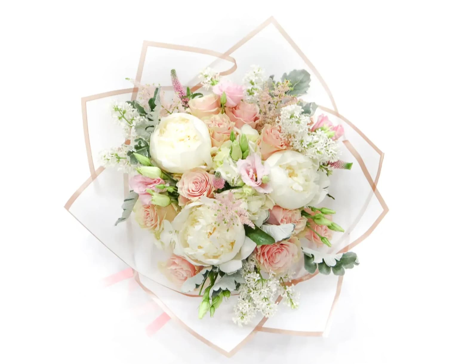 Bouquet of blush and white flowers wrapped in clear paper