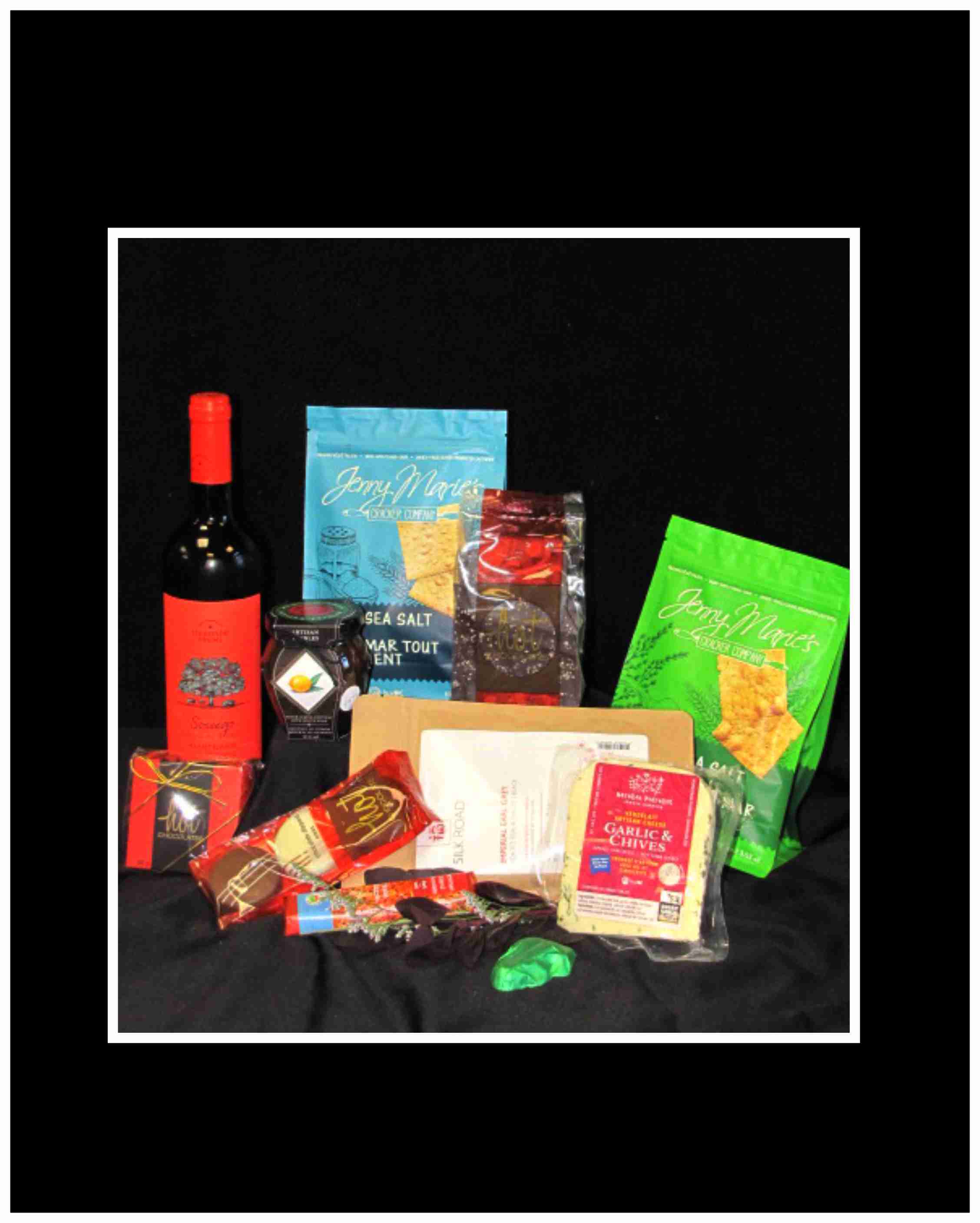 Assorted wine and snack gift items arranged on a black background