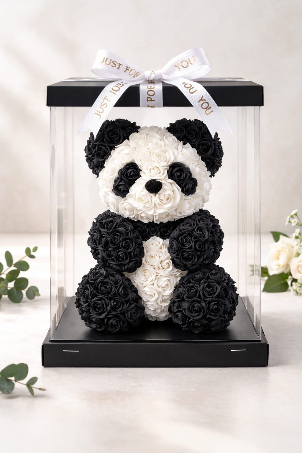 Black and white rose teddy bear in a clear gift box with a ribbon