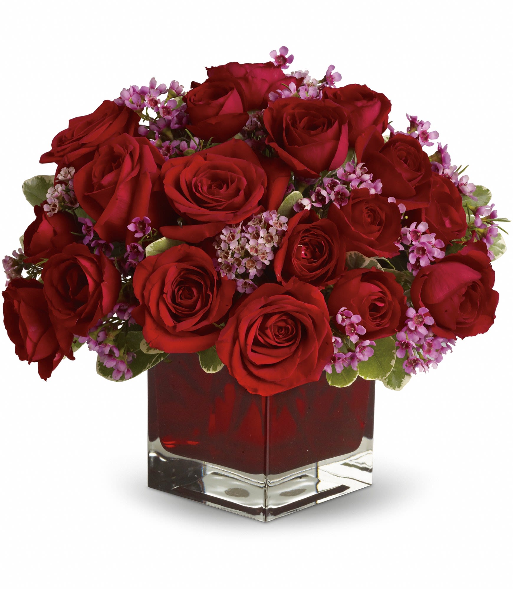Red roses and small pink flowers arranged in a square glass vase