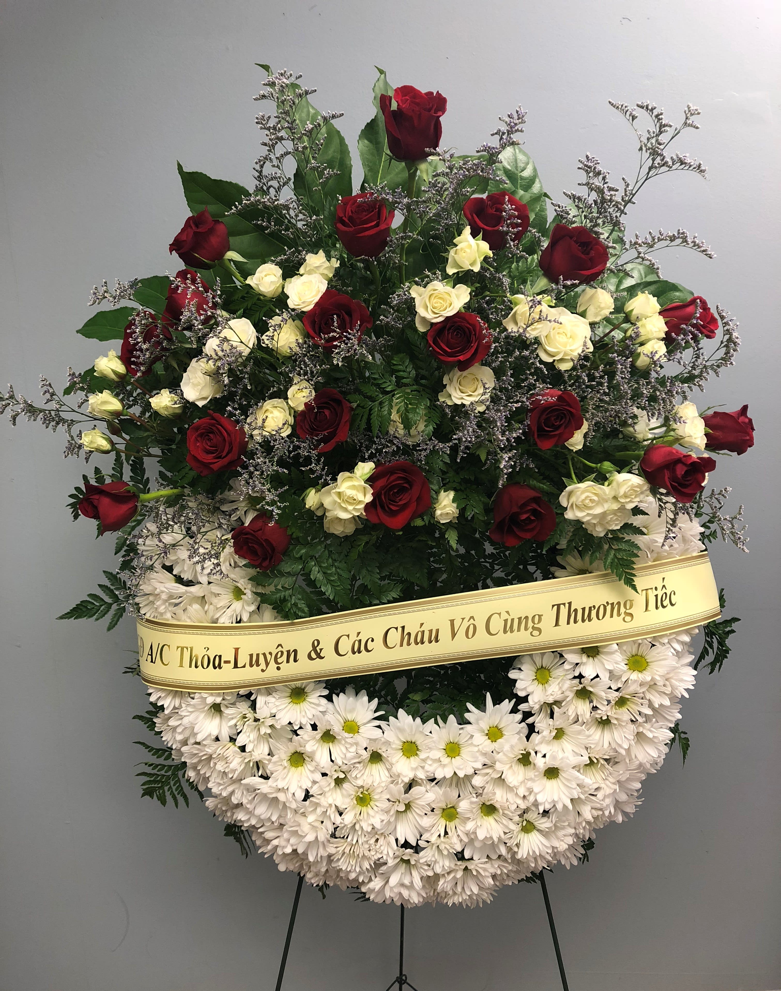 Standing funeral wreath of red and white roses with white daisies