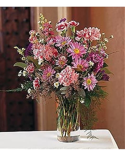 Pink &amp; Purple in Glass Vase - This simple bouquet filled with pinks and lavenders is the perfect gesture to show how much you care. Contains pink standard and miniature carnations, lavender stock and daisies, purple statice and white Monte Cassino asters in a cylindrical glass vase. 