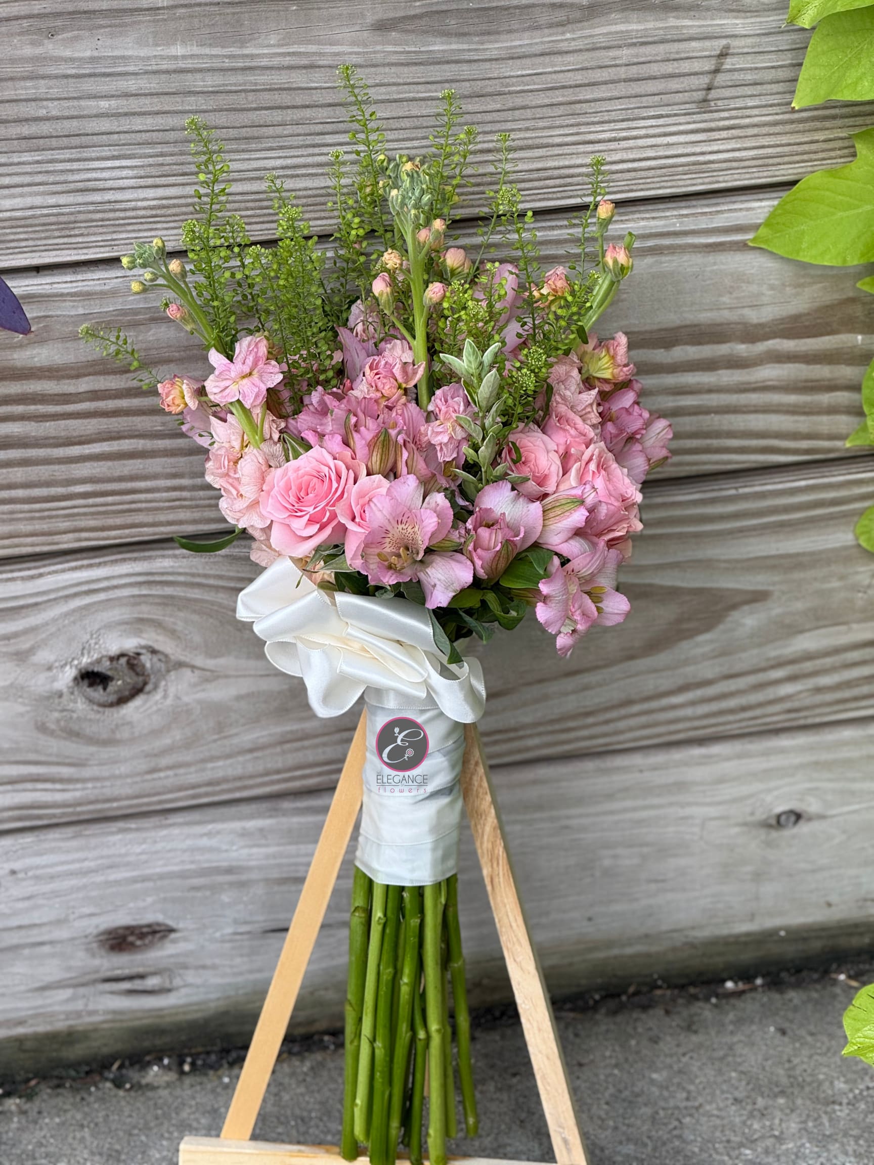 Pink bouquet with roses and alstroemeria tied with a white ribbon