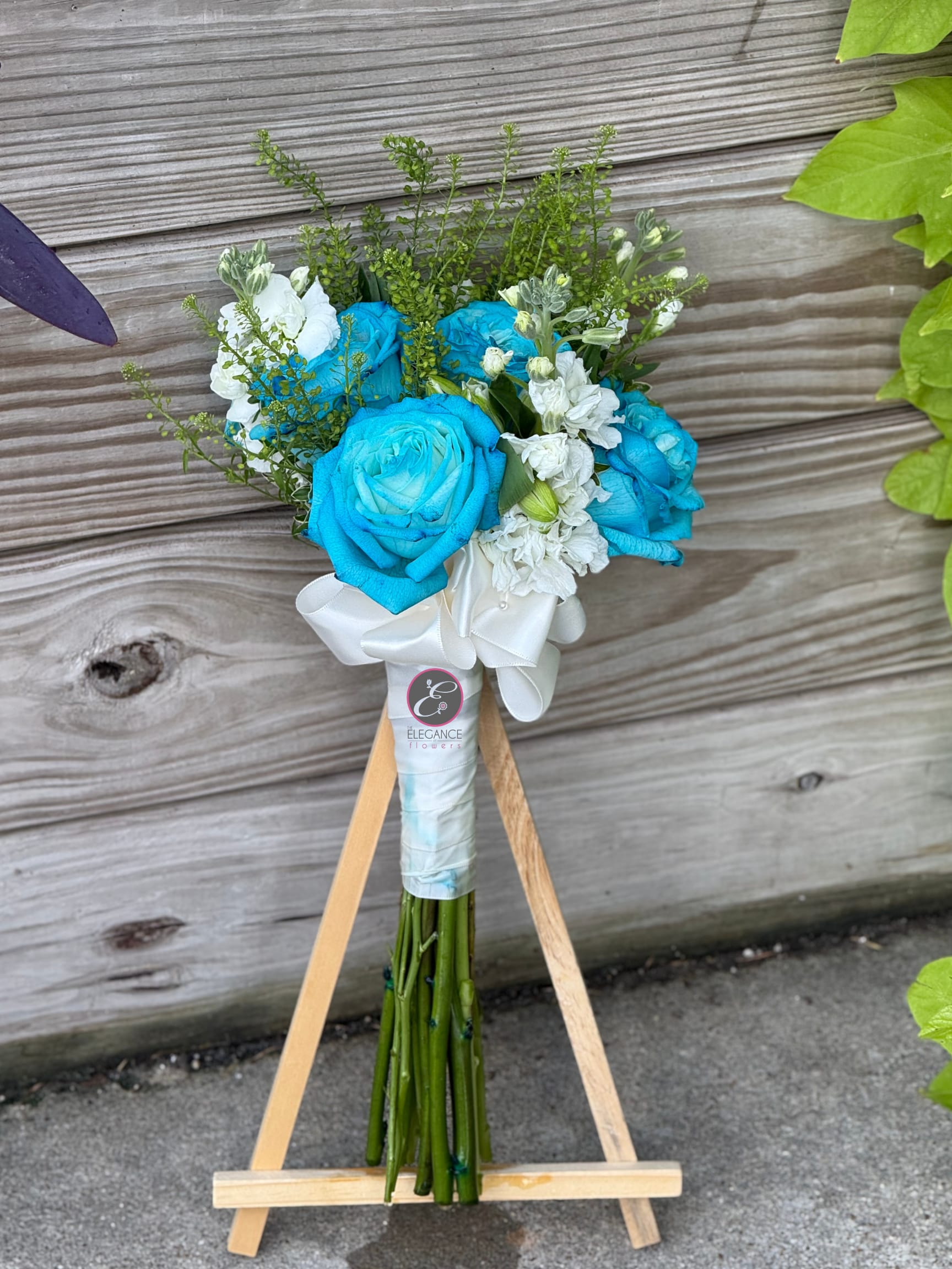Blue and white rose bouquet tied with a white ribbon