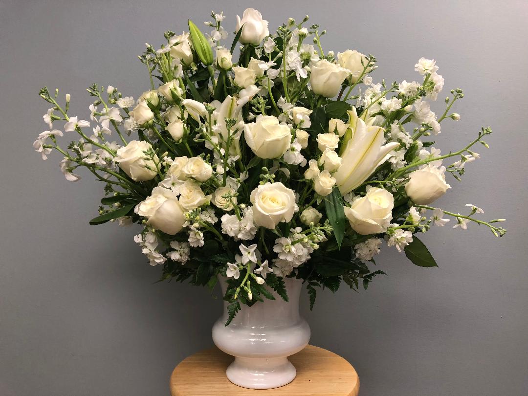 White roses and lilies arranged in a white vase