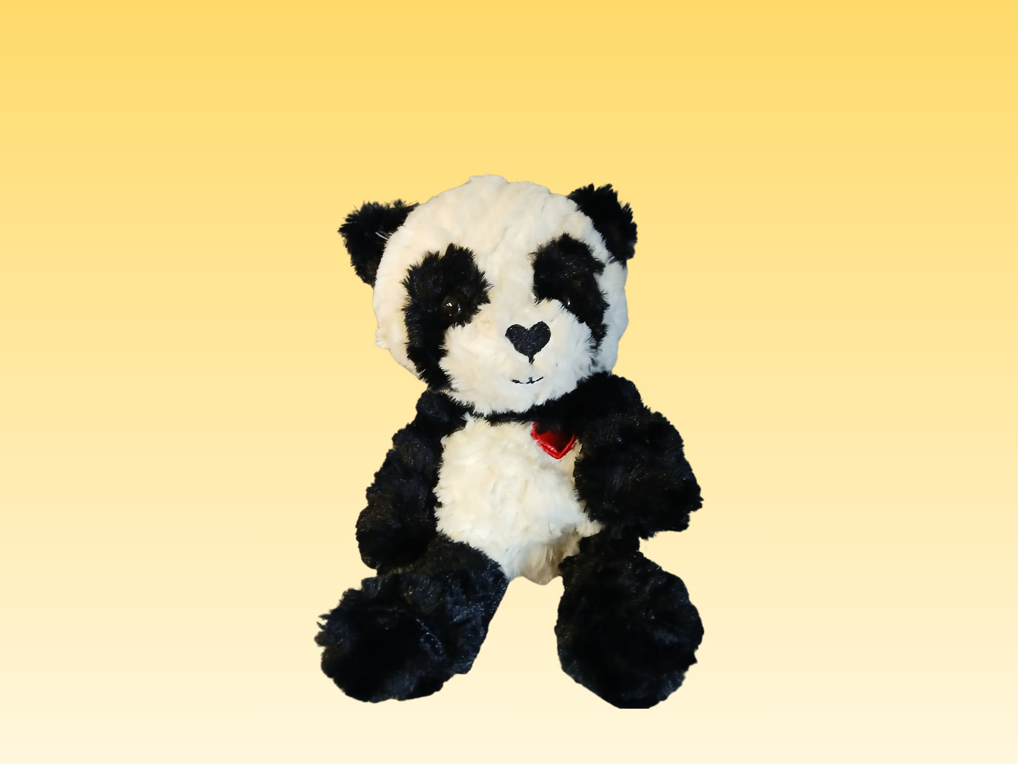 Black-and-white plush panda bear with a red heart on its chest