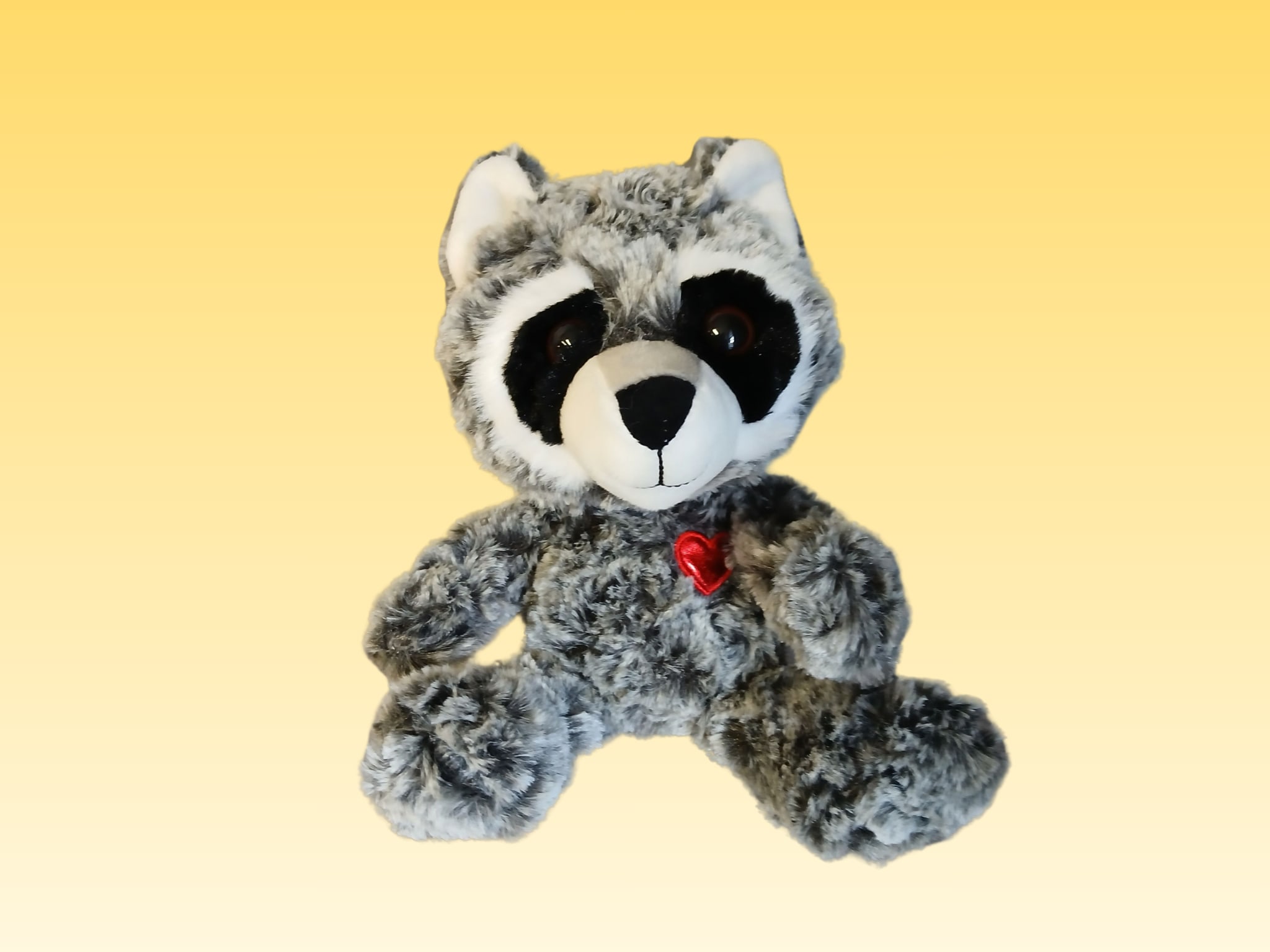 Plush raccoon with a small red heart on its chest