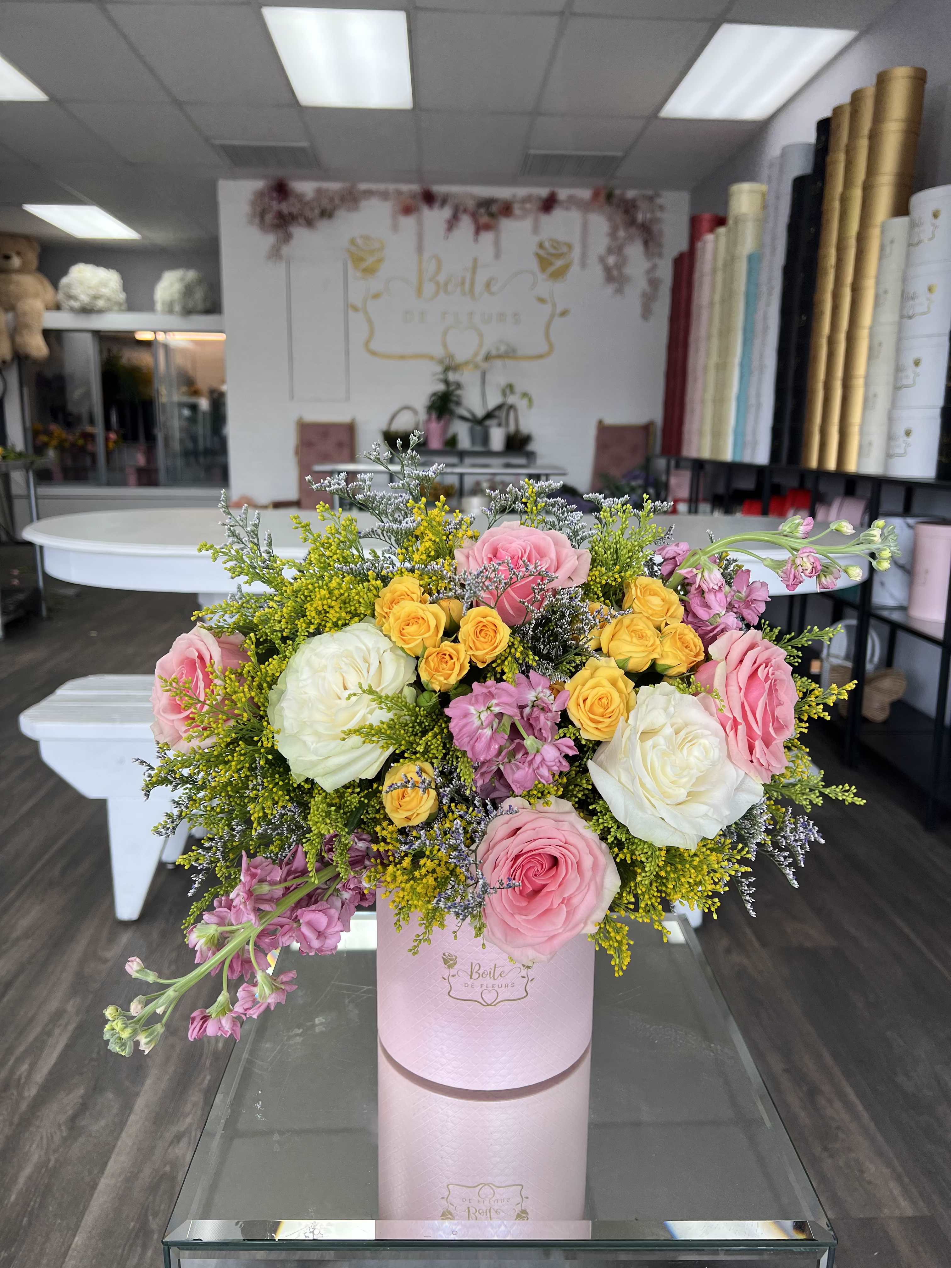Blushing Beauty - A soft blend of blush, yellow, and ivory roses arranged in a signature pink flower box, creating a romantic, garden-inspired look. This is the perfect pink flower arrangement for birthdays, a Mother’s Day gift, anniversaries, or for a just because surprise. This feminine floral gift adds a touch of elegance and luxury to any space.