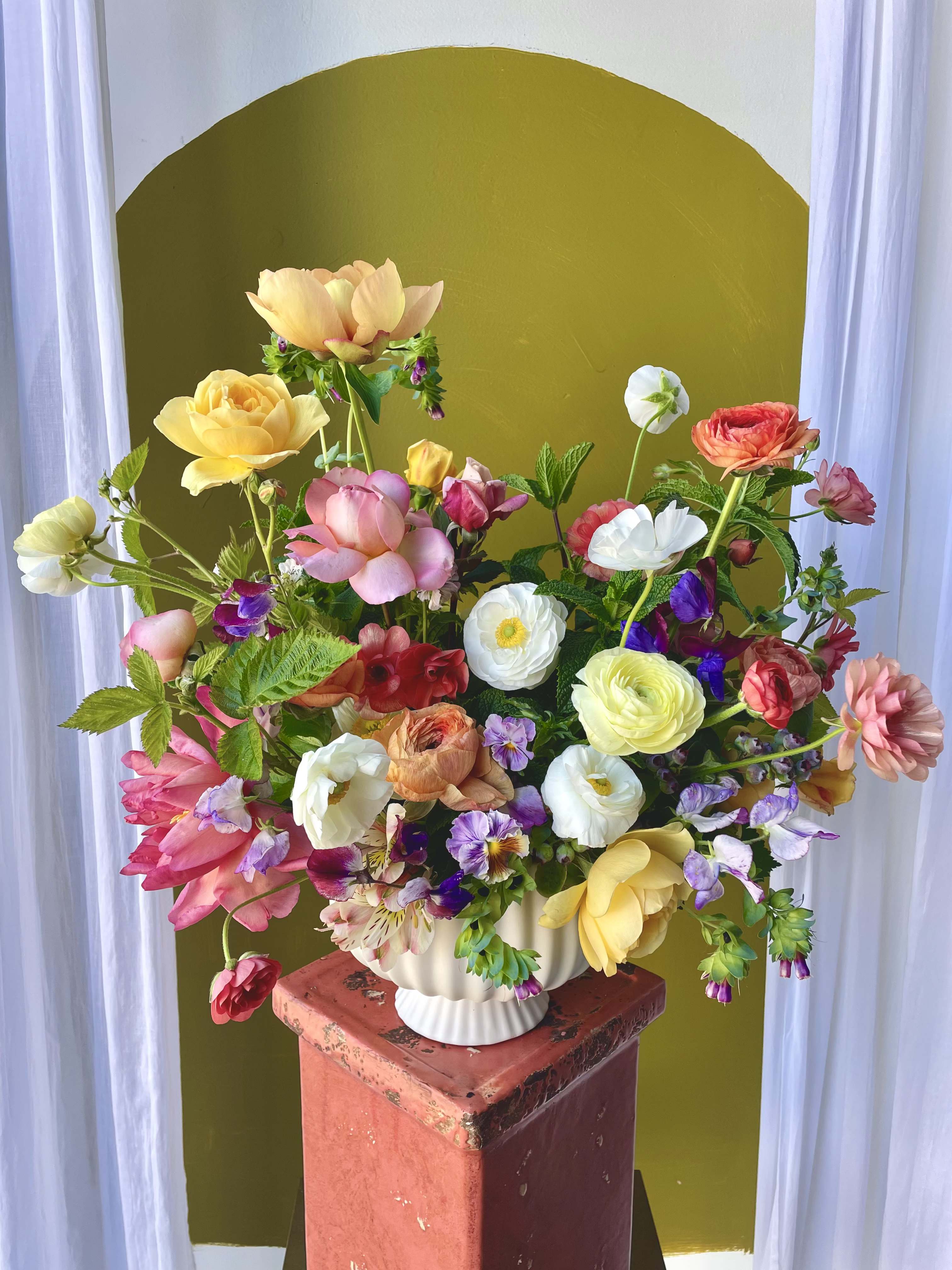 Mother's Day Colorful Arrangement - A whimsical garden-style arrangement packed with spring blooms in a colorful palette. Fashioned in a large white compote.   Concerning Seasonality: As a seasonal, locally-focused florist, we have different product to work with each week. Our focus is on creating a unique piece for each customer, with blooms that are fresh from local farms and growers. While the flower varieties and colors may vary, the quality and freshness will always be the best. It is an honor to have our customers' trust and confidence in our abilities and artistic eye.   Delivery Policy: Pick-ups at the studio are available after 2pm. Our daily delivery time frame is typically between 12- 3 PM. Please specify if you require a certain delivery time and we will do our best to accommodate it, or we will call you if we cannot. Please include any gate codes if applicable! If there is no answer at the door, our delivery person will leave the flowers by the doorstep in a weather safe location or contact you to reschedule the delivery.  Completing your order acknowledges that you have read and understand our delivery policies. 