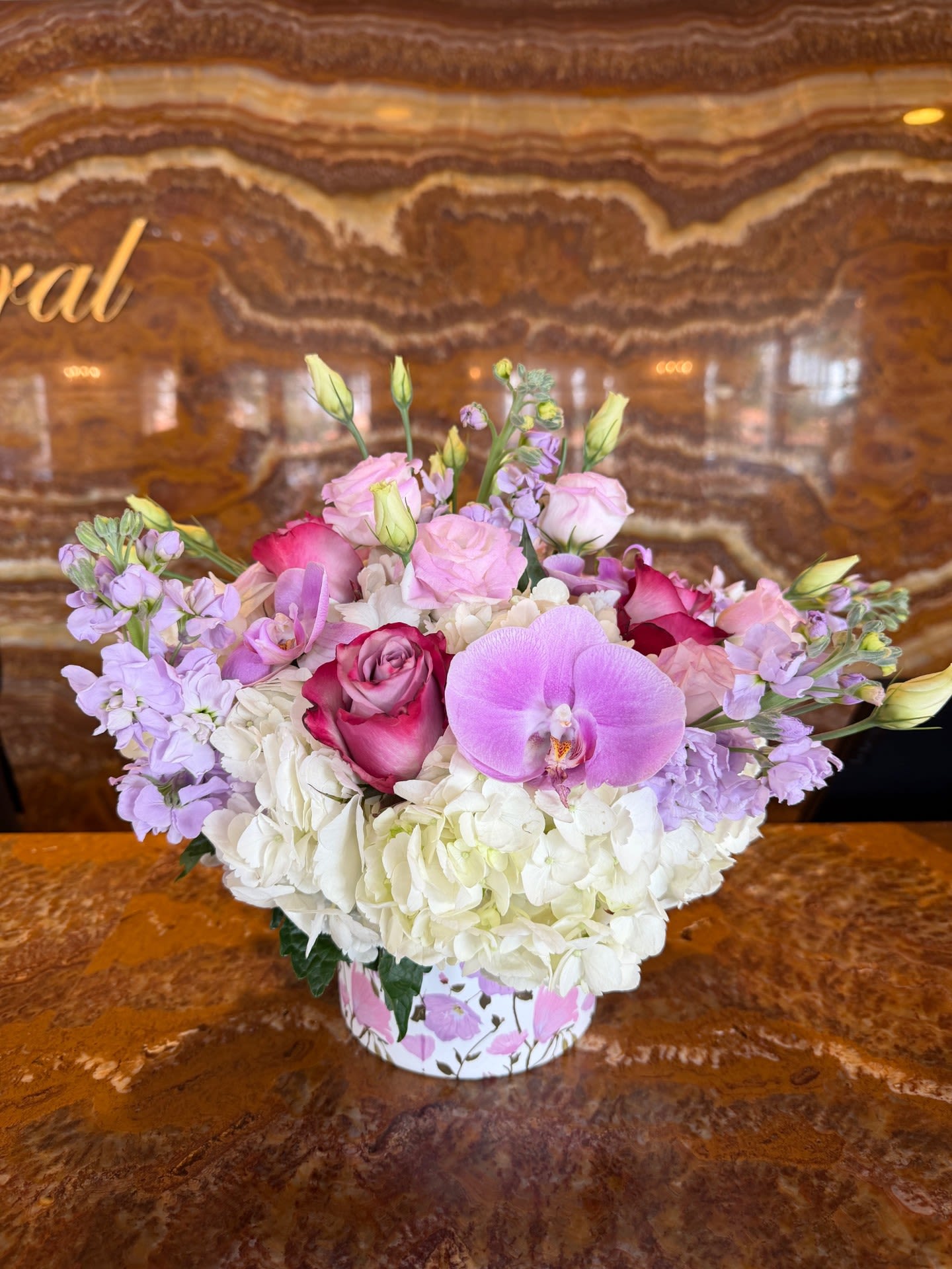 Pink and lavender bouquet with white hydrangeas in a floral box