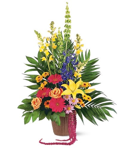 Tropical mixed flower arrangement in a brown basket with bright blooms