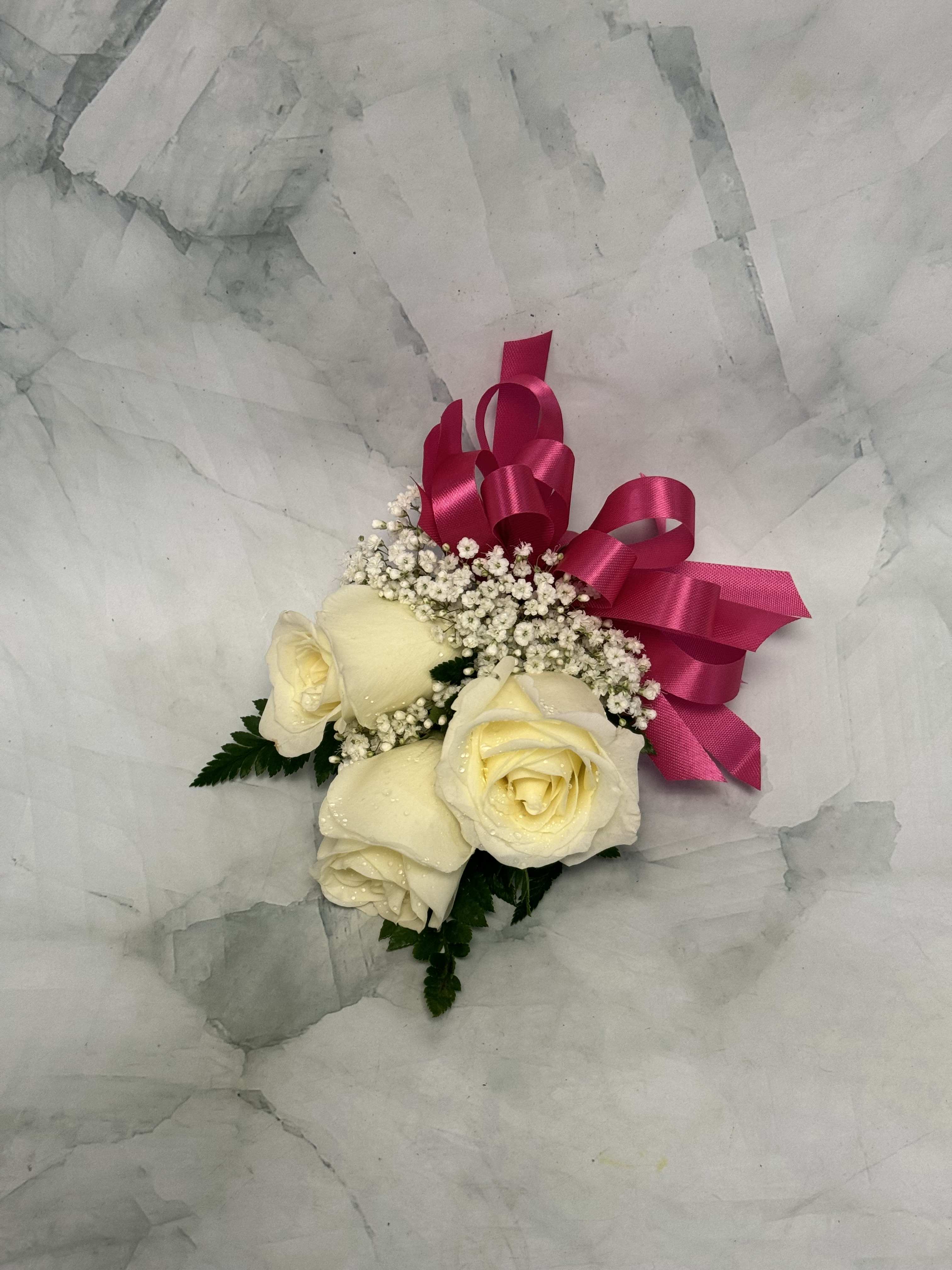 Cream roses with baby's breath and a pink ribbon bow