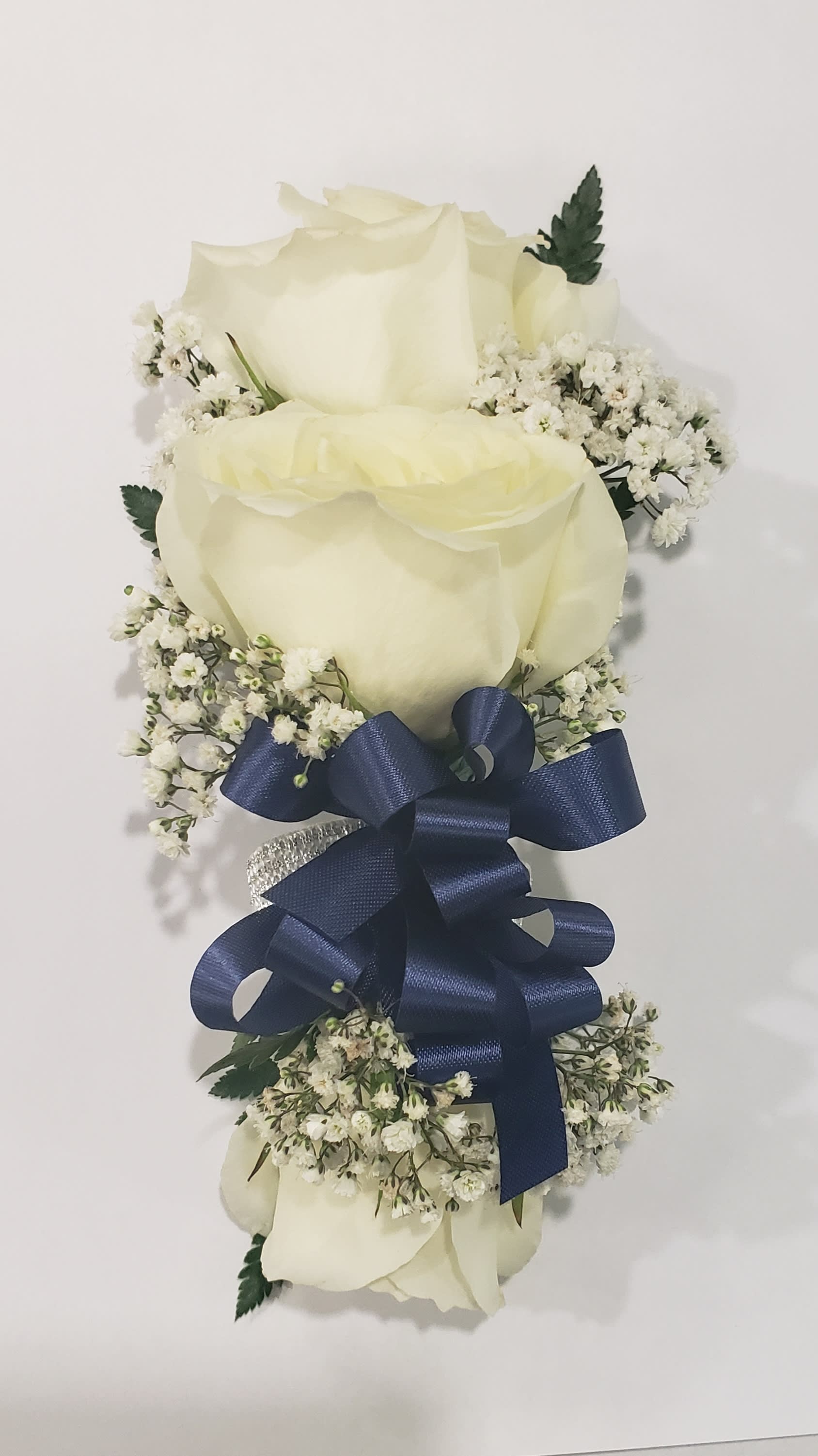 Three white roses with baby's breath and a navy ribbon