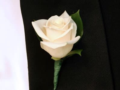 White rose boutonniere on a black suit jacket