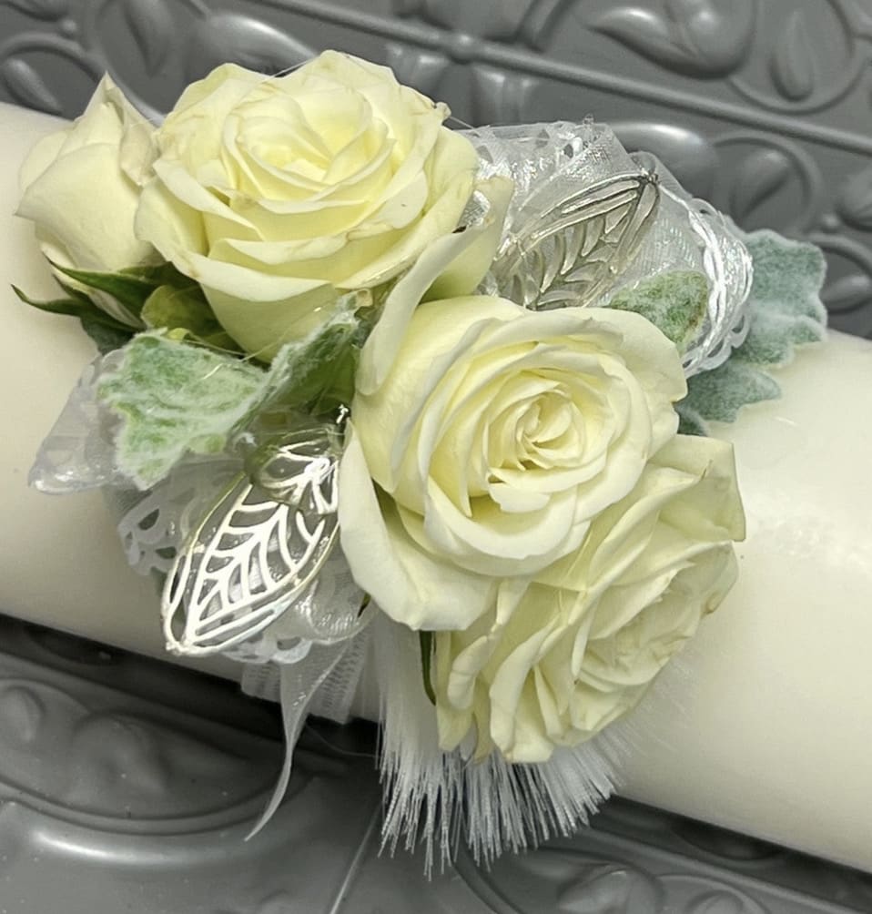 Tylor Corsage - This elegant corsage is crafted from delicate white rose flowers and adorned with a crisp white ribbon. The simplicity of the design creates a timeless and classic look that is perfect for any formal occasion, from prom to weddings. The pure white color of the roses and ribbon lend a sense of purity and innocence to the wearer, making it an ideal accessory for a bride, debutante, or anyone looking for a touch of understated sophistication.