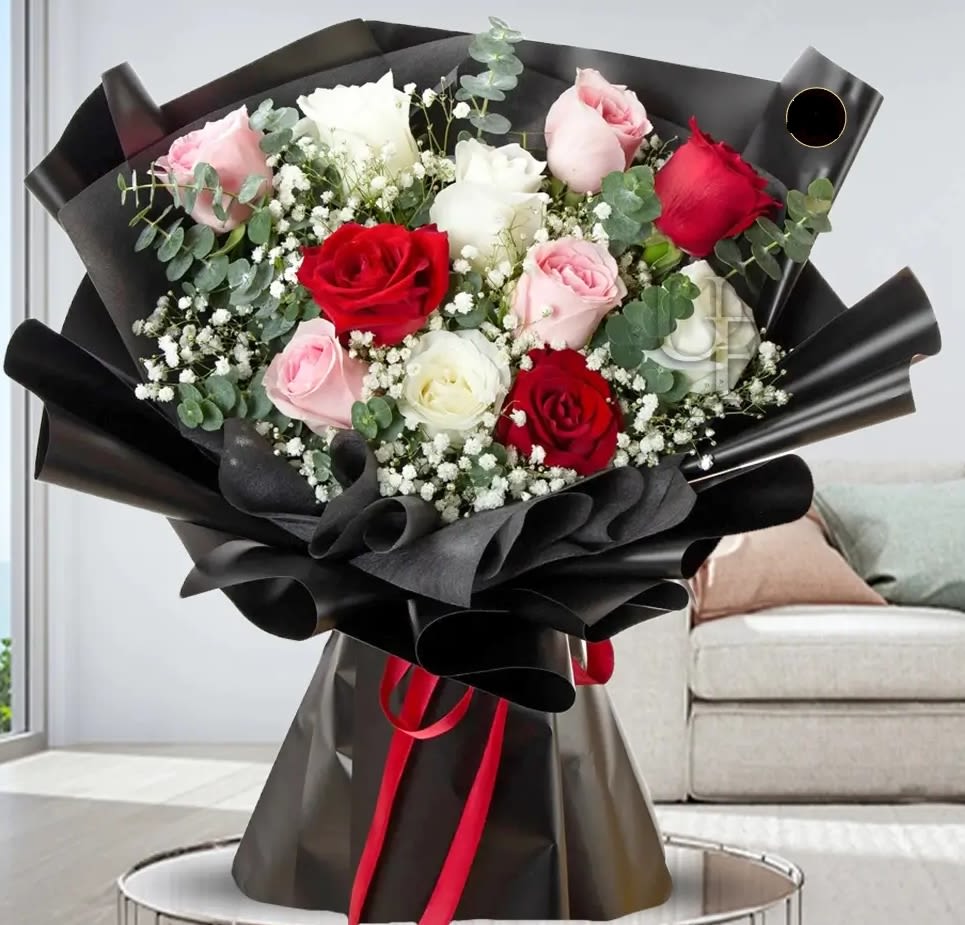 Bouquet of red, pink, and white roses wrapped in black paper