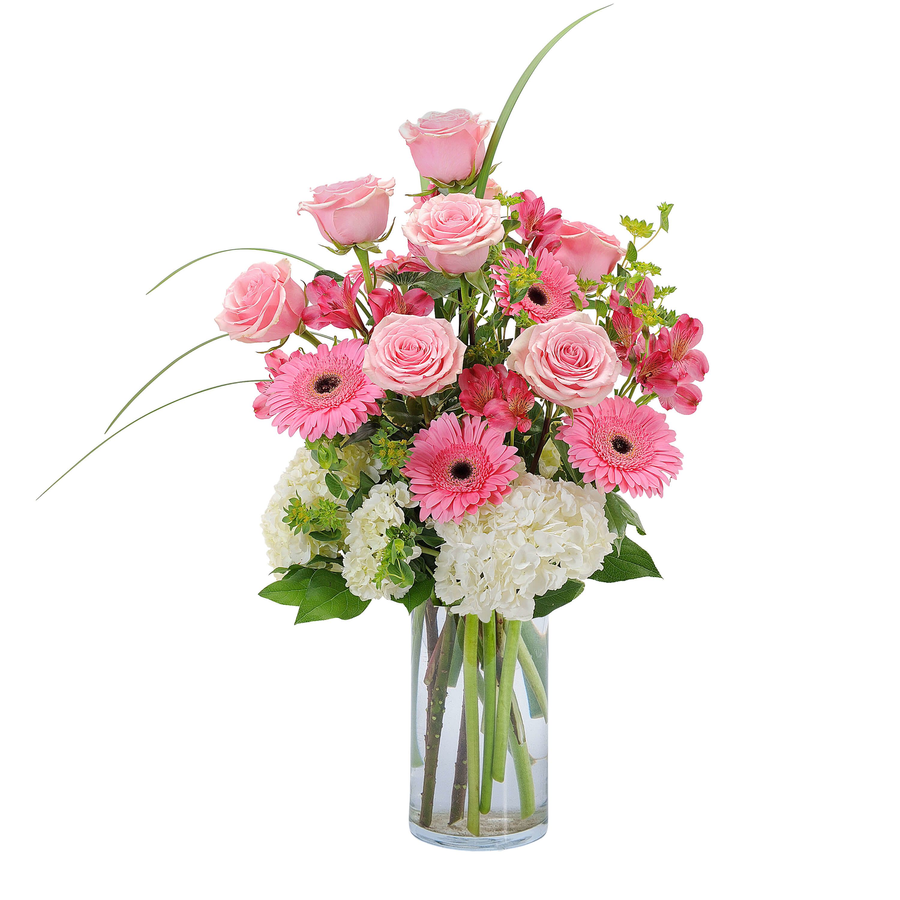 Pink Petals  - Pink roses, gerbera daisies, white hydrangea and alstroemeria combine to make this pretty pink arrangement in a clear glass vase appropriate for a dining table or kitchen island.  As similar as possible. Designer may make appropriate substitutions based on flower availability. 