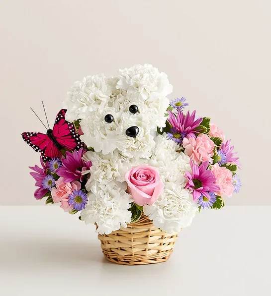 White teddy bear floral arrangement in a wicker basket with pink and purple flowers