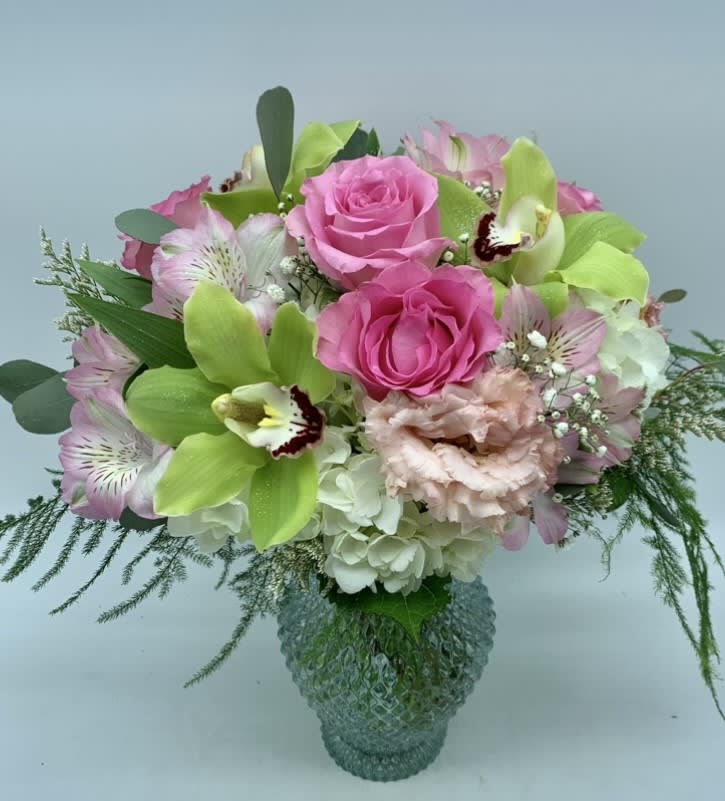 Pink roses and green orchids in a glass vase