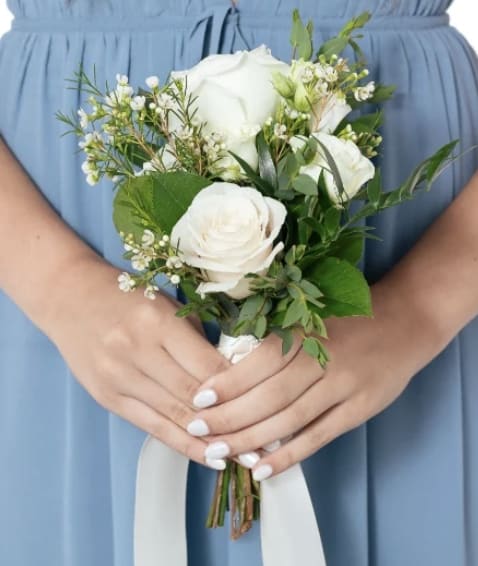 White rose bouquet with greenery and a white ribbon