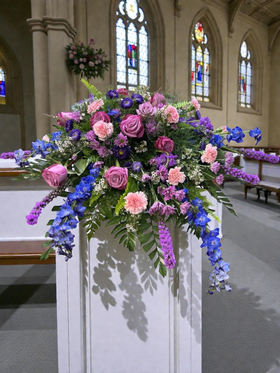 Lavender Legacy - Lavender Legacy is a graceful casket spray designed to bring calm, beauty, and quiet reflection to a funeral or memorial service. A harmonious blend of lavender, blue, and soft pink flowers creates a peaceful, garden-inspired palette that feels both comforting and refined.  The design moves naturally across the casket, with soft layers and balanced texture that give it a full, flowing presence without feeling heavy or overworked.  Each arrangement is thoughtfully handcrafted by Aspen Tower Florist using fresh blooms and intentional composition to honor a life remembered with love.  Available for casket flower delivery through Aspen Tower Florist, serving Shelbyville and Greensburg along with Rushville, Batesville, Westport, Oldenburg, St. Paul, Waldron, Milroy, and Hope.