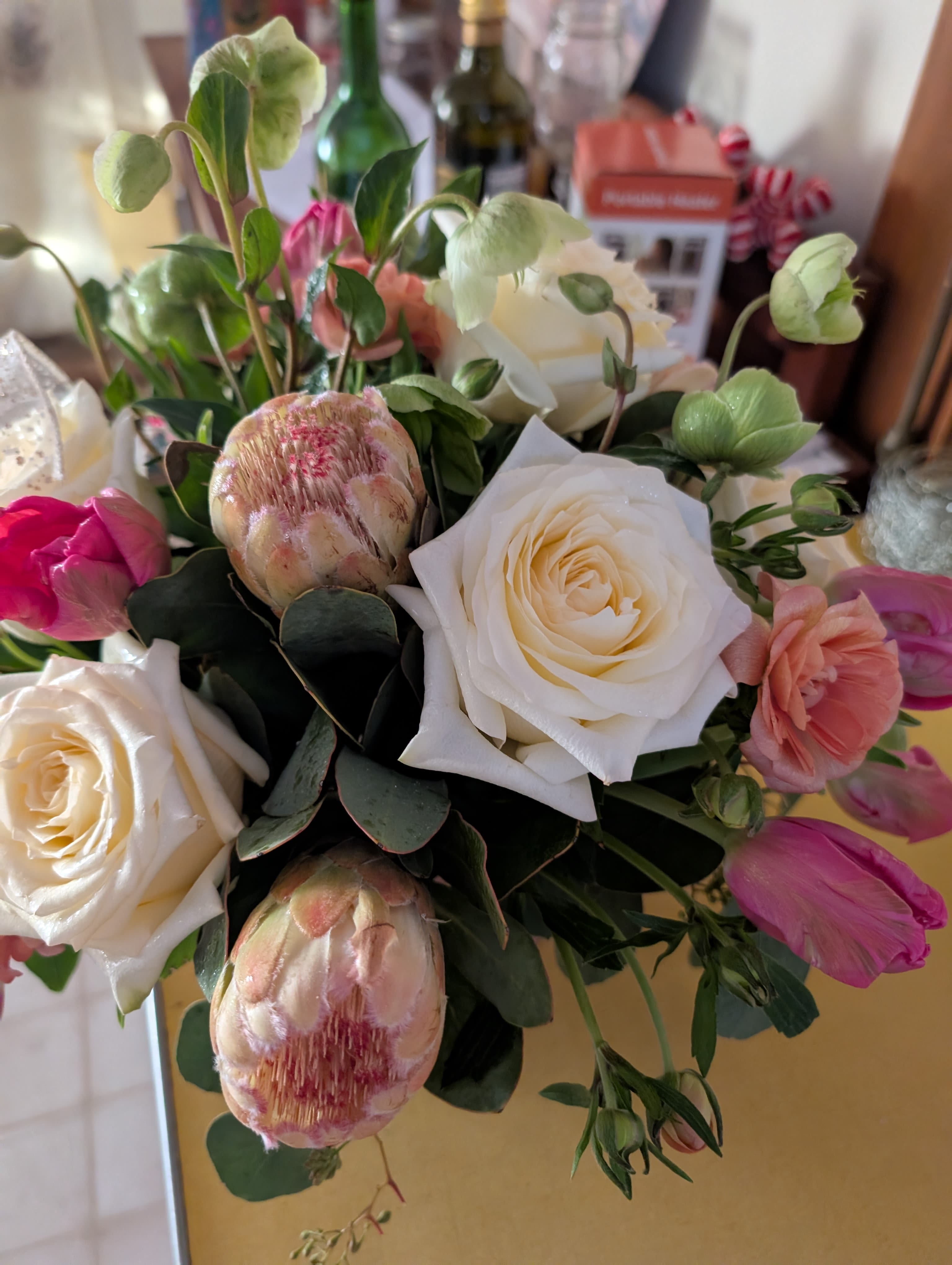 Tropical Vase - A soft, garden-inspired bouquet that feels like a sunlit corner of a conservatory - this flower arrangement is a romantic spring gift perfect for birthdays or anniversaries. The Tropical Vase pairs large creamy white roses with blush pink tulips and pale protea buds to create a layered, tactile look that makes the recipient feel truly seen and celebrated.  Closely arranged and hand-tied for a full, lush silhouette, the mix of velvety rose petals, delicate tulip cups, and the unique texture of protea buds is set against deep green foliage for fresh contrast. Colors range from warm whites to soft pinks with leafy greens, offering a versatile palette that suits both intimate moments and cheerful celebrations.  Ideal for someone who appreciates garden-style charm, this arrangement arrives ready to display in a favorite vase or on a dining table as a centerpiece. For best enjoyment, keep blooms in fresh water and out of direct heat to prolong vase life.
