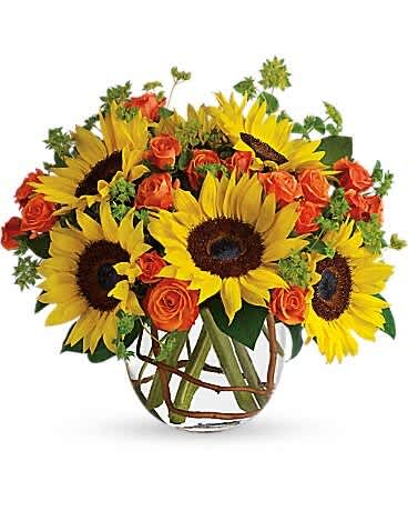 Sunflowers and orange roses arranged in a clear glass vase