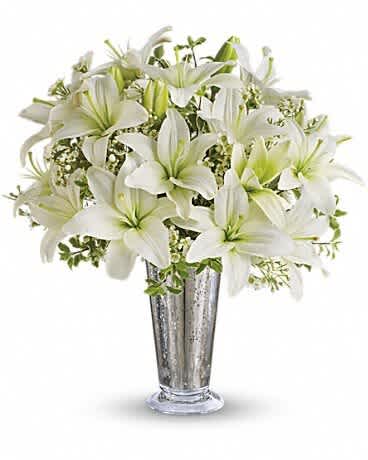 White lilies arranged in a tall silver vase